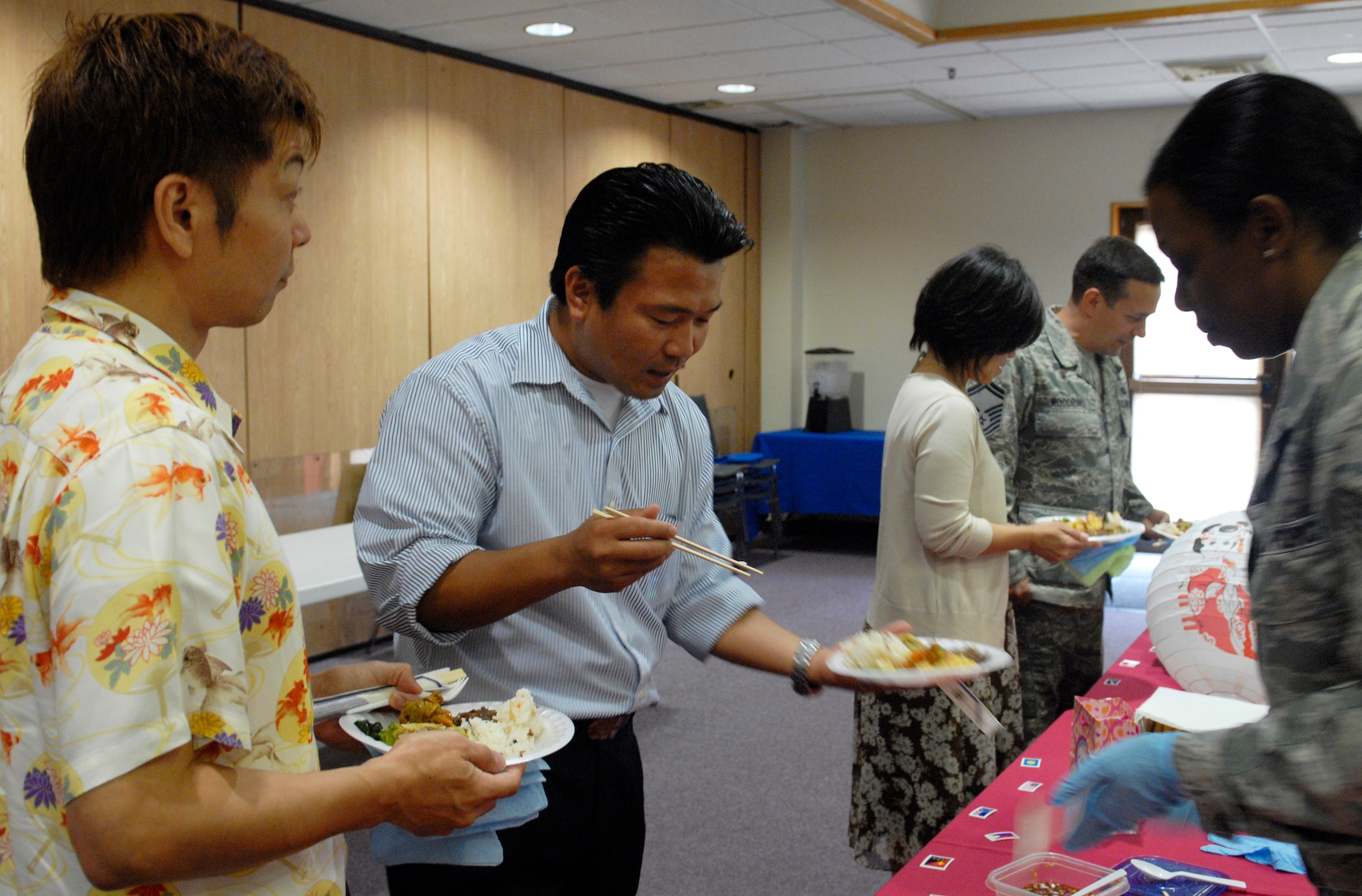 Base members try a rice dish at the Asian-Pacific American Heritage taste testing event on Kadena Air Base, Japan, May 29, 2012. The people who came to taste the food were given tickets to vote on their favorite main dish and side dish. There will be an APAH Month wrap-up breakfast at the Rocker NCO Club at 7:30 a.m. May 31. (U.S Air Force photo/Airman 1st Class Malia Jenkins)