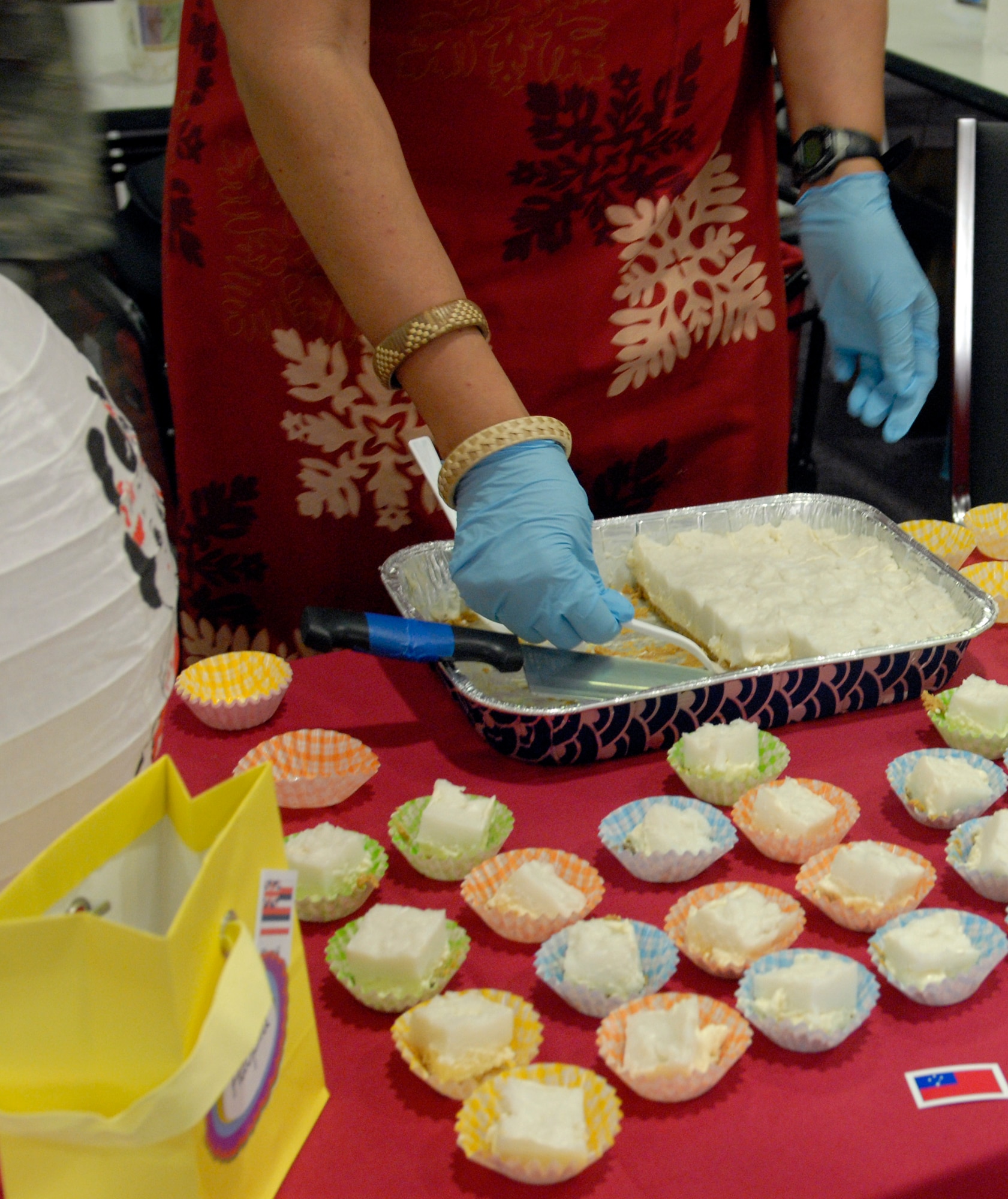 An Asian-Pacific American Heritage committee member serves a Hawaiian dish to members from the base at the Schilling Center on Kadena Air Base, Japan, May 29, 2012. The APAH Committee held a cultural taste testing event with a variety of food from Hawaii, Philippines and Japan. There will be an APAH Month Wrap-up Breakfast at the Rocker NCO Club at 7:30 a.m. May 31. (U.S Air Force photo/Airman 1st Class Malia Jenkins)
