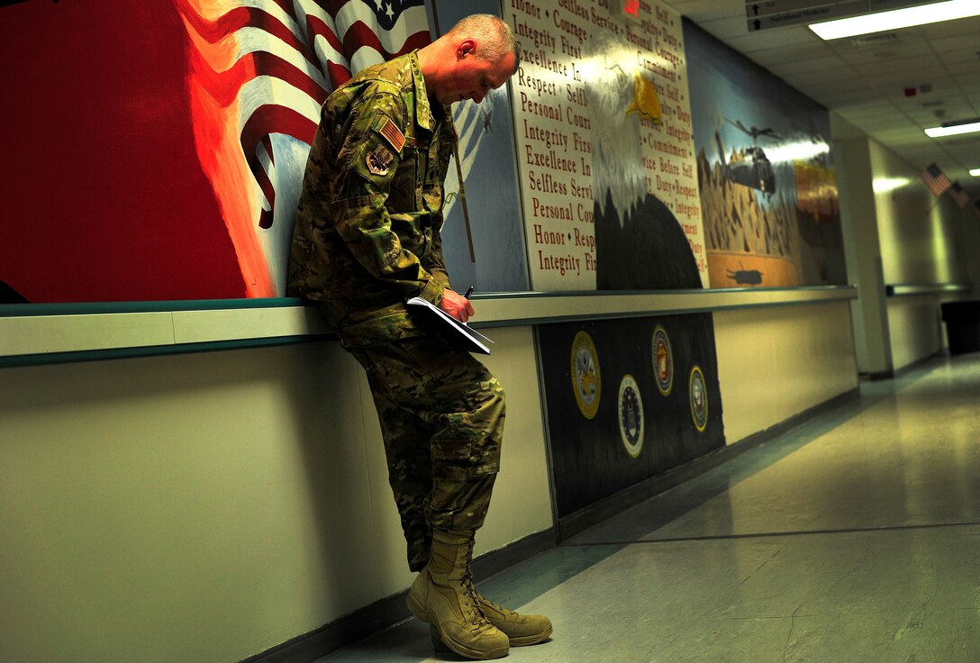 Air Force Chaplain (Lt. Col.) Brian Bohlman, 455th Air Expeditionary Wing ., native, writes a reminder in between prays with the patients of the Craig Joint Theater Hospital, Bagram Airfield, Afghanistan, May 26, 2012. Chaplain Bohlman, a Bel Air, Md. native, works the night shift at the hospital and routinely visits patients, American and Afghan, throughout the night helping them to cope with their circumstances. The hospital here employs 528 joint medical staff.(U.S. Air Force photo/Staff Sgt. Clay Lancaster)