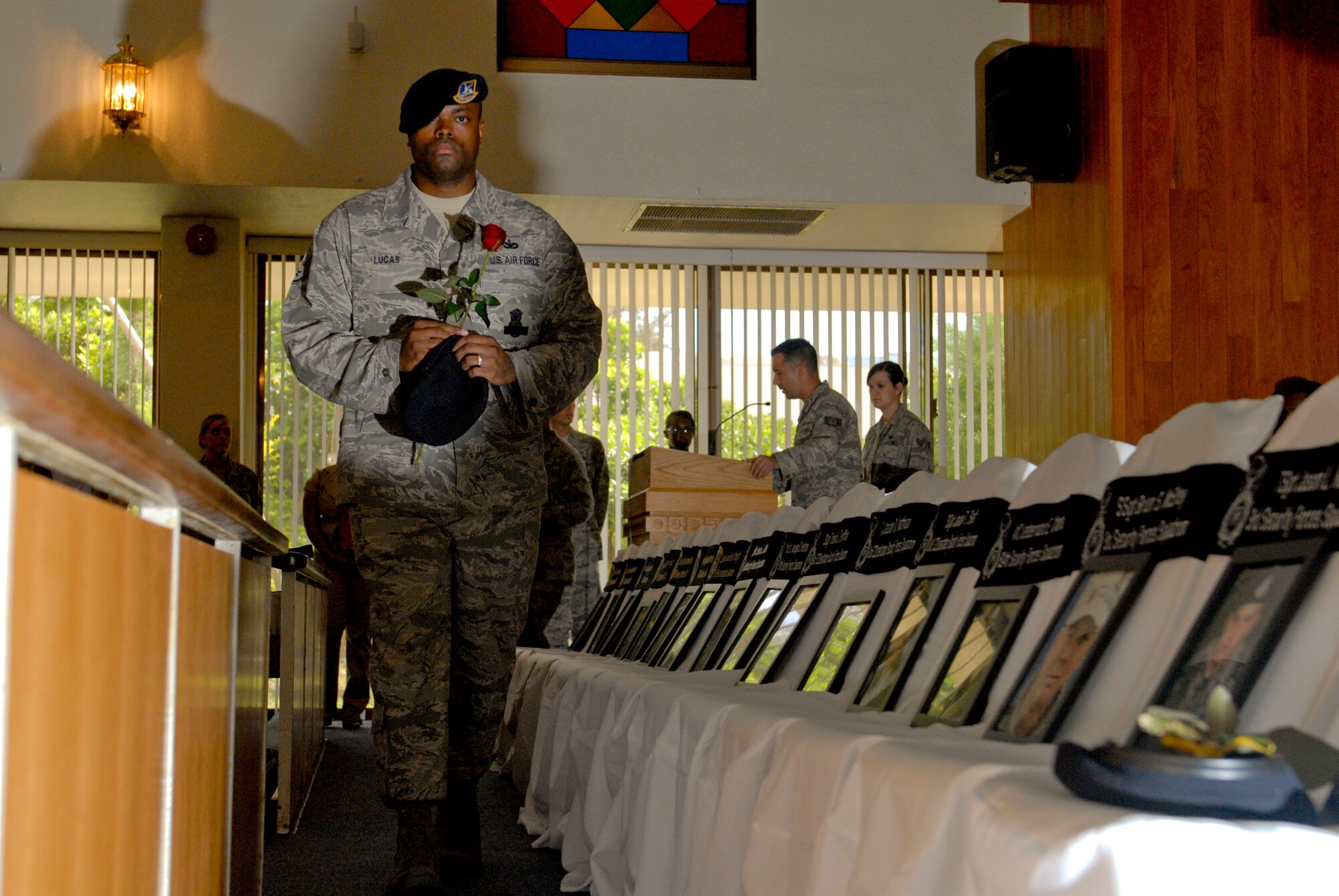 The sergeant-at-arms, Staff Sgt. Maurice Lucas II, presents roses to security forces and Office of Special Investigations personnel who have given their lives in the line of duty during a National Police Week memorial service at Chapel Two on Kadena Air Base, Japan, May 24, 2012. The red rose and yellow ribbon placed on each chair demonstrated how each fallen comrade still remains in the hearts and minds of fellow security forces and OSI agents. (U.S Air Force photo/Airman 1st Class Malia Jenkins)    