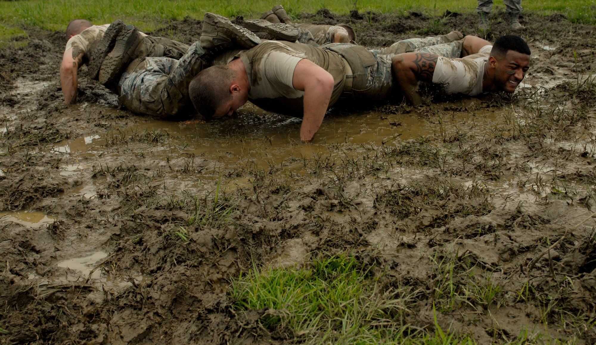 (Left to right) Airman 1st Class Brandon Spears, Airman 1st Class Kenneth Stuart, Airman 1st Class Rashawn Richards and Airman 1st Class Joshua Sutton (center facing away) perform warrior push-ups at a mudpit next to 18th SFS Headquarters on Kadena Air Base, Japan, May 22, 2012. Warrior push-ups were the final task of the defenders challenge between 18th Security Forces Squadron and joint service teams. (U.S Air Force photo/Airman 1st Class Malia Jenkins)  