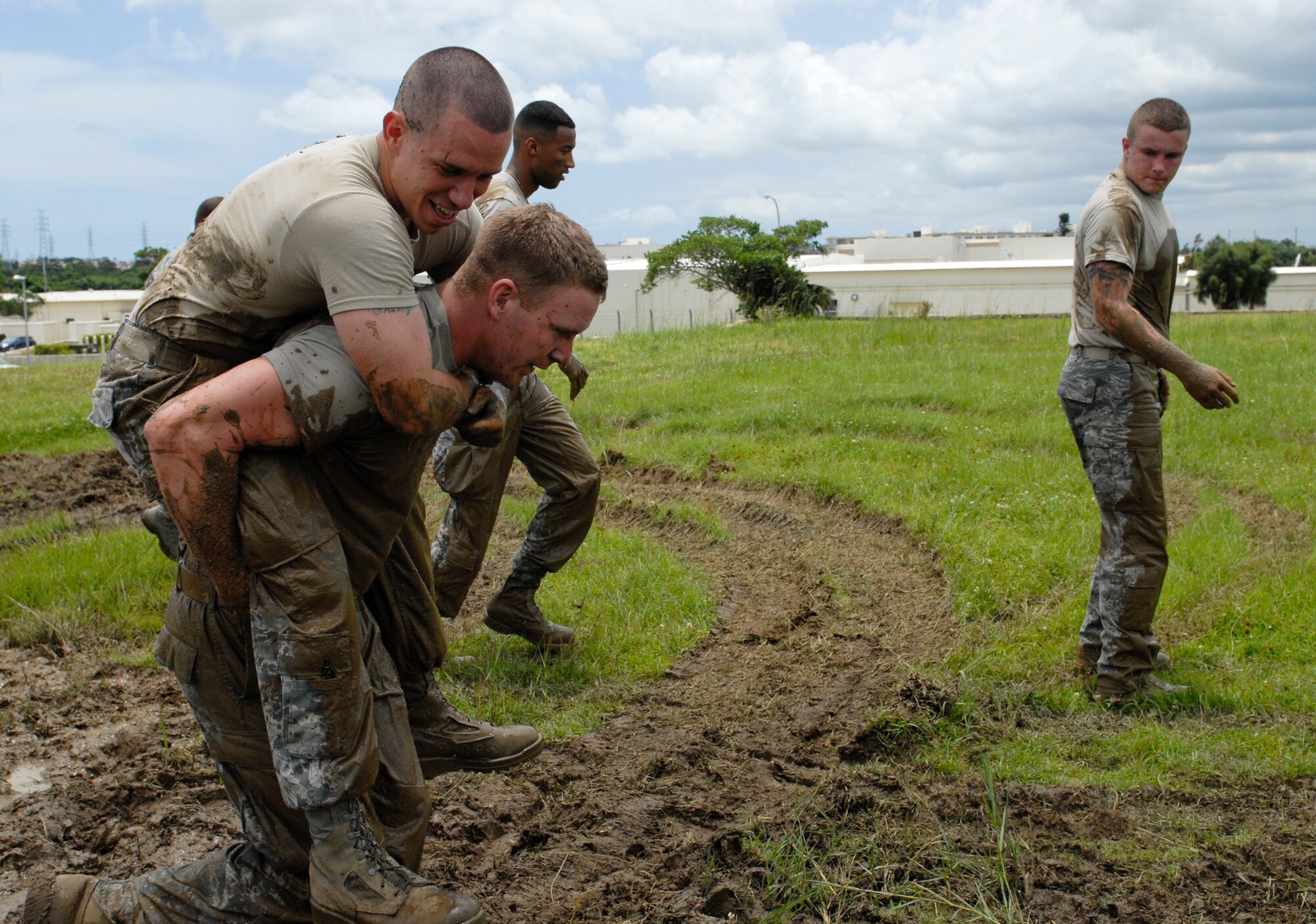 Airman 1st Class Brandon Spears is carried by Airman 1st Class Joshua Sutton while Airman 1st Class Rashawn Richards  and Airman 1st Class Kenneth Stuart observe during the defenders challenge at 18th SFS Headquarters on Kadena Air Base, Japan, May 22, 2012. After conducting five warrior push-ups, the team carried each other down the field and back. Team Charlie outscored the U.S. Army team before them by 40 points and won the competition. (U.S Air Force photo/Airman 1st Class Malia Jenkins)  