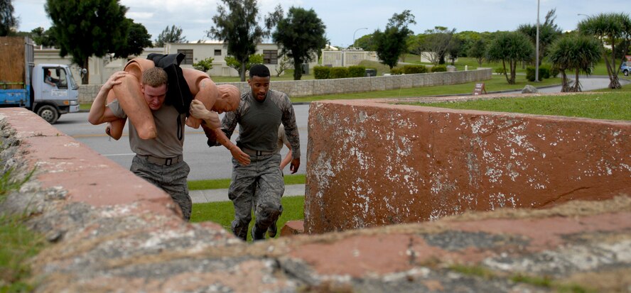 Airman 1st Class Joshua Sutton and Airman 1st Class Rashawn Richards of Team Charlie rescue a simulated downed pilot from the Risner Fitness Complex during National Police Week activities held on Kadena Air Base, Japan, May, 22, 2012. The teams ran from Marek Park to the Risner fitness center and back to the 18th Security Forces Squadron. (U.S Air Force photo/Airman 1st Class Malia Jenkins)  
