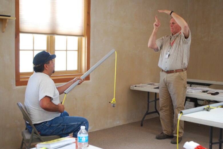 Arthur Kunigel shows a student how to use correct hand signals for safe crane operations.  