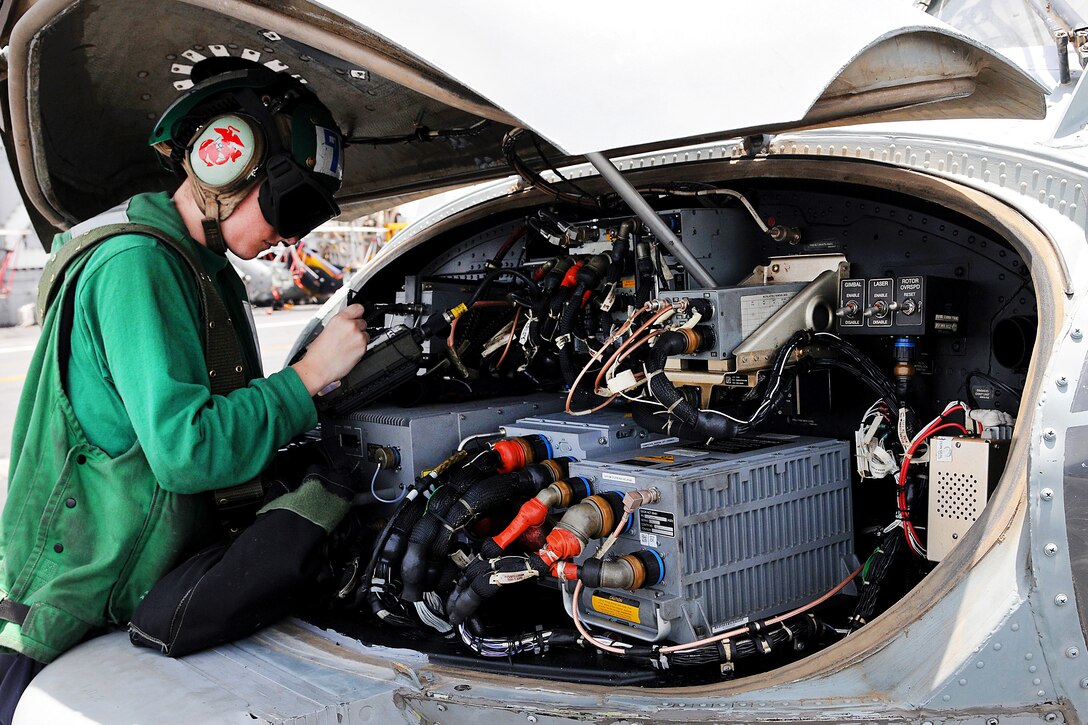 A U.S. seaman checks the electrical system of an MH-60R Seahawk helicopter on the flight deck of the aircraft carrier USS Abraham Lincoln under way in the Arabian Sea, May 24, 2012. The seaman, a aviation electrician’s mate, is assigned to Helicopter Maritime Strike Squadron 77.