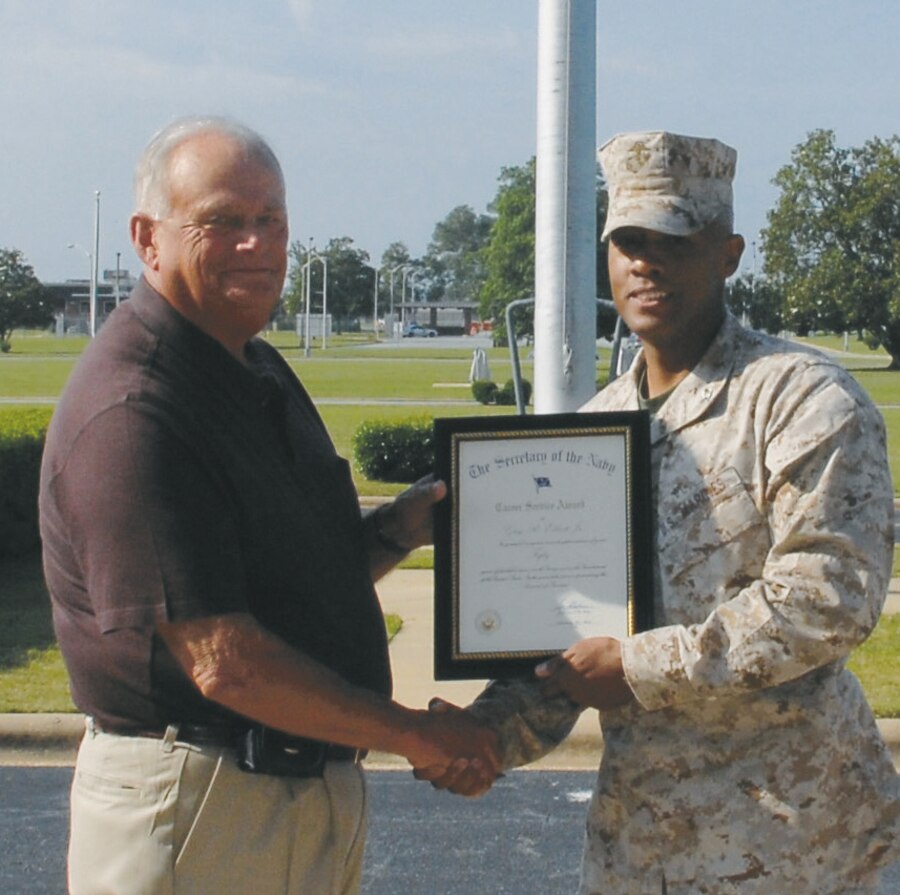 Mike Elliott Jr., Garrison Mobile Equipment supervisor with Logistics Support Division, Marine Corps Logistics Base Albany, receives a 50-year length of service award from Col. Terry V. Williams, former commanding officer, MCLB Albany, during a ceremony held?May 16 in front of Building 3500. Elliott served in the Marine Corps from 1958-1978 and retired with the rank of gunnery sergeant. He began working here in 1981.
