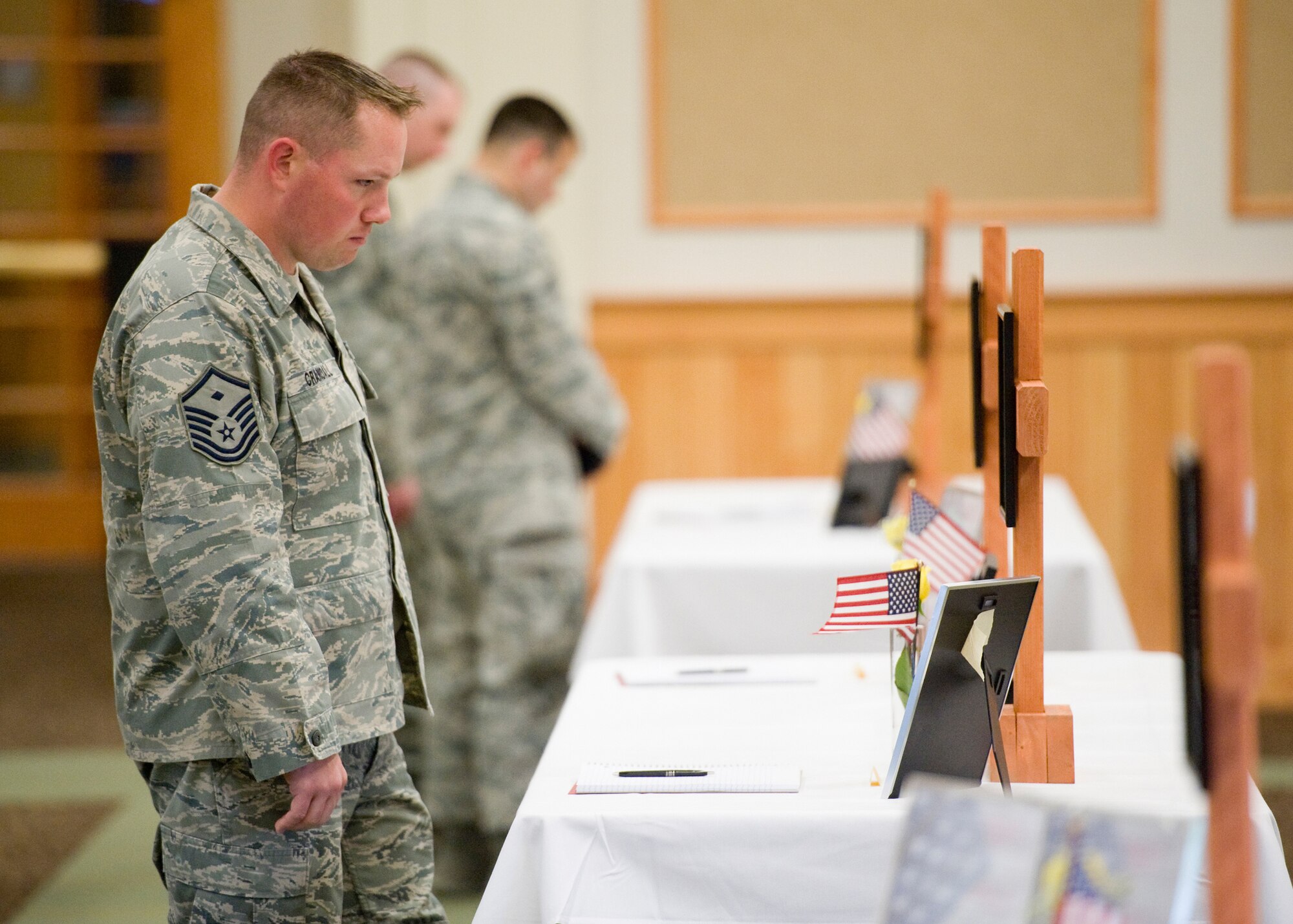 Master Sgt. Colin Crandall, 341st Medical Group first sergeant, visits one of the 11 tributes to a fallen security forces member May 24. Airmen attending the memorial event were encouraged to write notes to the families of the defenders honored. (U.S. Air Force photo/Beau Wade)