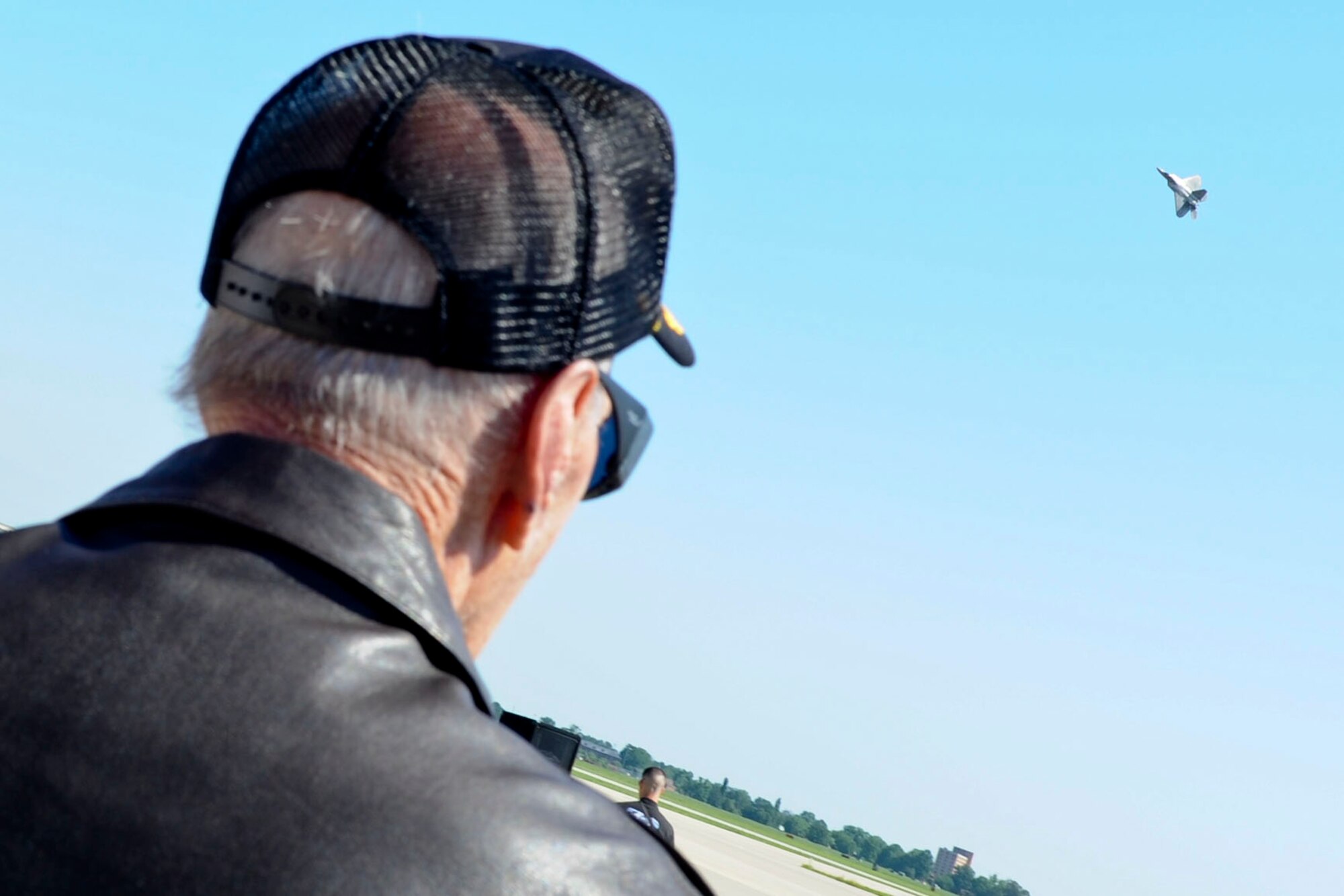 World War II pilot and Distinguished Service Cross recipient Jim Tapp watches as an F-22 Raptor perform a demo in the skies above him on the flight line at Langley Air Force Base, Va., as part of a base tour for the Legion of Valor, May 31, 2012. Tapp, who flew the P-51 Mustang, earned the title of “Ace” after downing eight Japanese aircraft in aerial combat, four of which were in a single day. (U.S. Air Force photo by Senior Airman Wesley Farnsworth/Released)