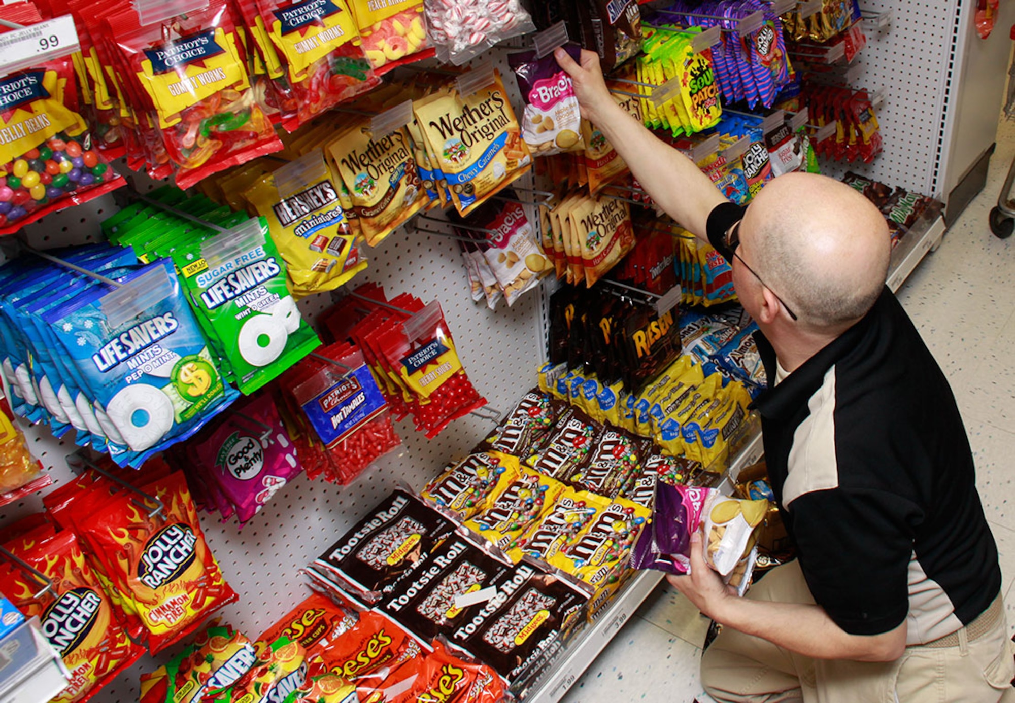 PITTSBURGH IAP ARS -- Andrew Pachesky, store manager of the 911th Airlift Wing Base Exchange, adjusts the candy shelving according to the stores planogram, May 31, 2012. Army and Air Force Exchange Service (AAFES) stores use detailed planograms, layouts of the store design, to efficiently place merchandise and provide a visually appealing assortment of items to their customers. A new commissary and exchange is slated to be built near the Army’s 316th Expeditionary Sustainment Command Headquarters, which is located a half mile from the 911th. (U.S. Air Force photo by Airman 1st Class Justyne Obeldobel/Released)