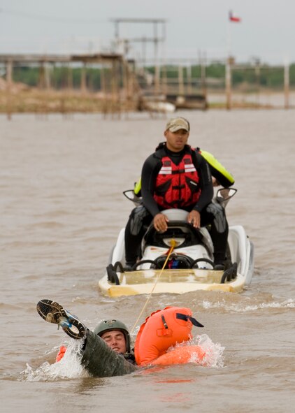 Airman 1st Class James Spangler, 39th Airlift Squadron, releases himself from his parachute vest after being dragged during water survival training May 9, 2012, at Lake Fort Phantom in Abilene, Texas. The water survival course refreshes airmen on events that might occur during an aircraft water landing. (U.S. Air Force photo by Airman 1st Class Peter Thompson/ Released)