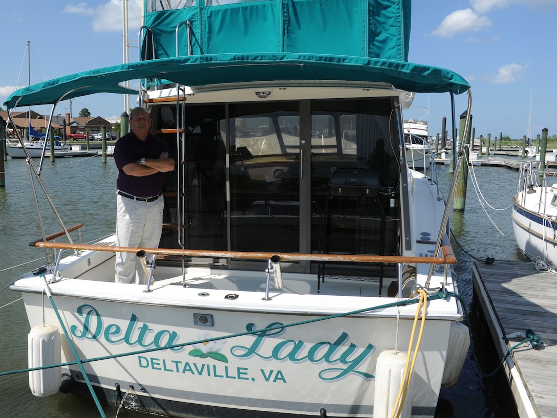 Richard Watson, a Navy Special Emphasis Operations Atlantic team leader with the Defense Contract Management Agency, stands in perspective to his ship, the Delta Lady, at Langley Air Force Base Va., May 29, 2012. Watson docked his 32-foot cruiser at the Langley Marina to keep his boat secure. (U.S. Air Force photo by Airman 1st Class Austin Harvill/Released)