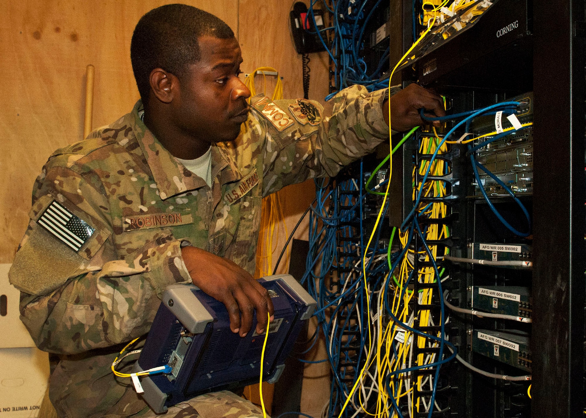 Senior Airman Darrius Robinson, 455 Expeditionary Communication Squadron network technician, checks the network speed of a fiber which supports the Vulture Net morale wireless network on Bagram Airfield, Afghanistan, May 31, 2012. Robinson was part of the crew that expanded the Vulture Net coverage area.  Robinson is deployed from Barkesdale Air Force Base, La., and is a native of Robbins, Ga.  (U.S. Air Force photo/Staff Sgt. Jeff Nevison)