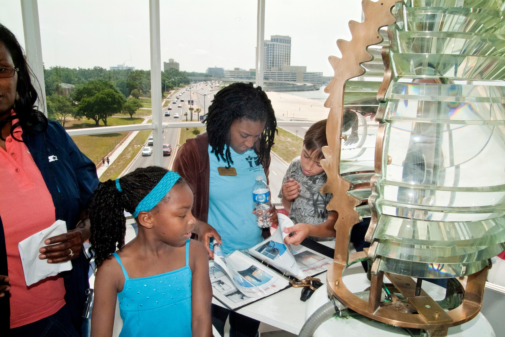 From left, Ashyton Graham, daughter of Allyson Hill, 81st Communications Squadron, Keesler Air Force Base, Miss.; Jamie Mignott, child and youth program assistant; and Chandler Belford look at an information binder at the top of the Biloxi Lighthouse during a Keesler Youth Center tour May 25, 2012.  (U.S. Air Force photo by Herb Welch)