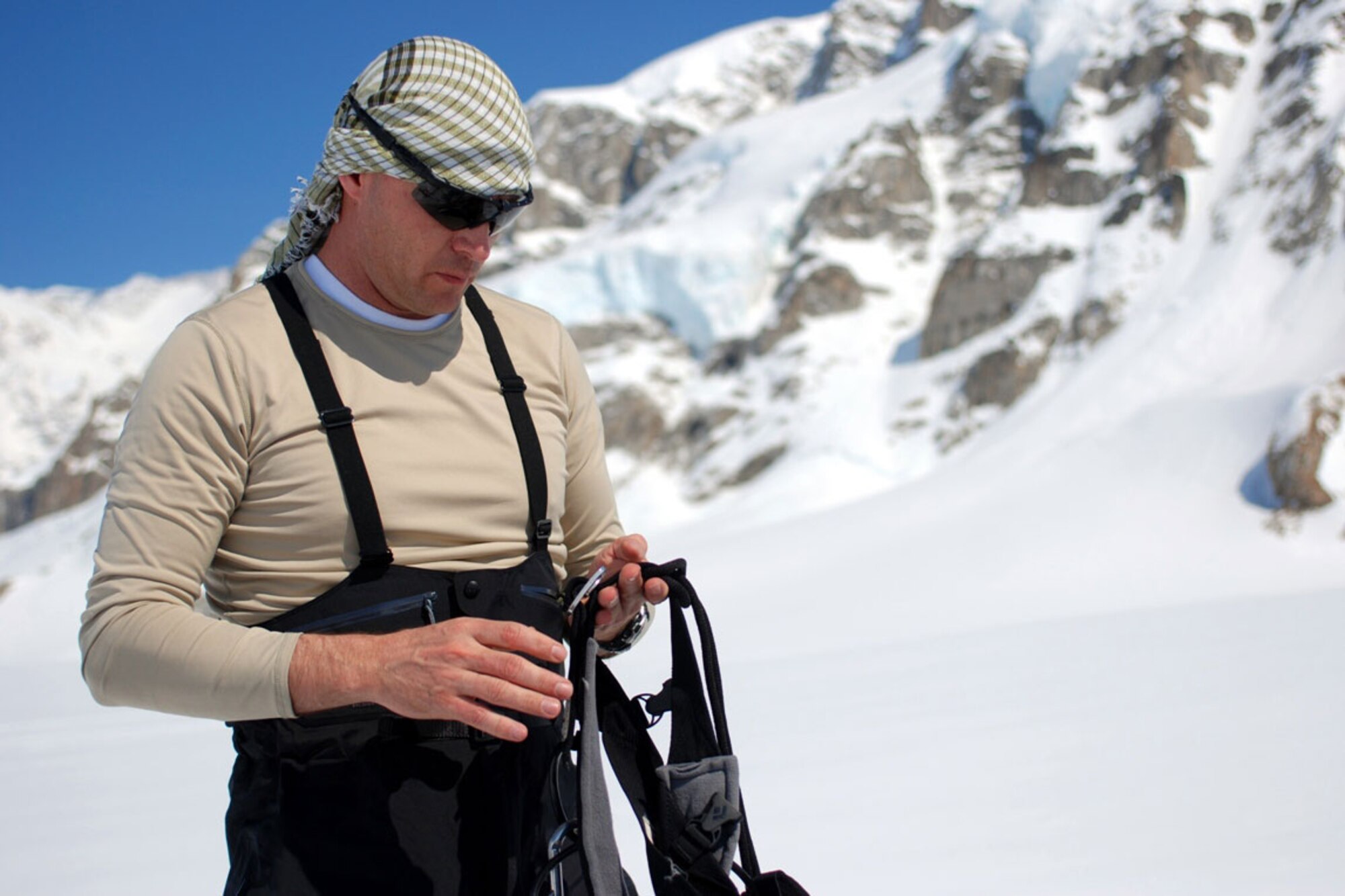 Maj. Gary McDonald, commandant of the U.S. Army Alaska Northern Warfare Training
Center inspects his harness and climbing equipment May 17 in preparation for his
team climb up Mount McKinley. Additional protective covering for the exposed skin,
like the cloth covering shown here is vital as refl ected solar radiation from the ice
and snow can more than double a person’s UV exposure on the glacier. (U.S.
Army photo/Staff Sgt. Matthew E. Winstead)