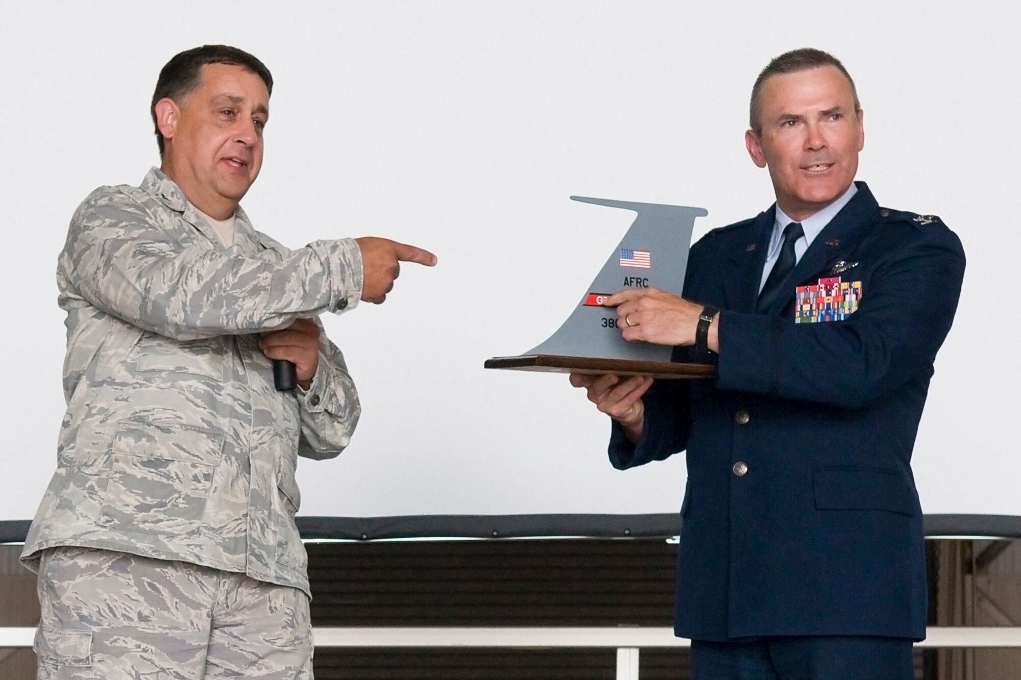 GRISSOM AIR RESERVE BASE, Ind. -- Col. William T. "Tim" Cahoon, right, shows an audience assembled at his retirement ceremony here May 20 that a KC-135R Stratotanker tail model has both blue and red on its tail flash. Col. Paul Weimer, 434th Maintenance Group commander, left, presented Cahoon with the special memento. (U.S. Air Force photo/Senior Airman Jami K. Lancette)