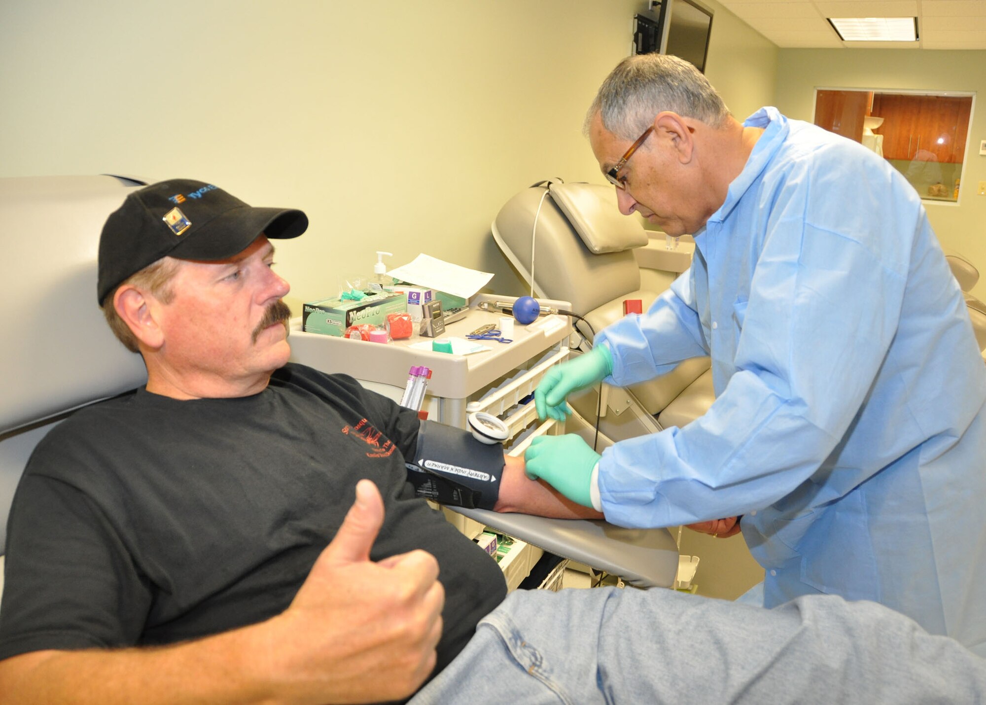 Jake Jacobsen, 81st Communications Squadron, gives a spontaneous “thumbs-up” May 18, 2012, as Tommy Joseph, 81st Diagnostics and Therapeutics Squadron medical laboratory technician, prepares to draw the pint of blood that will mark a total of six gallons he has donated to date at Keesler Air Force Base, Miss.  (U.S. Air Force photo by Steve Pivnick)