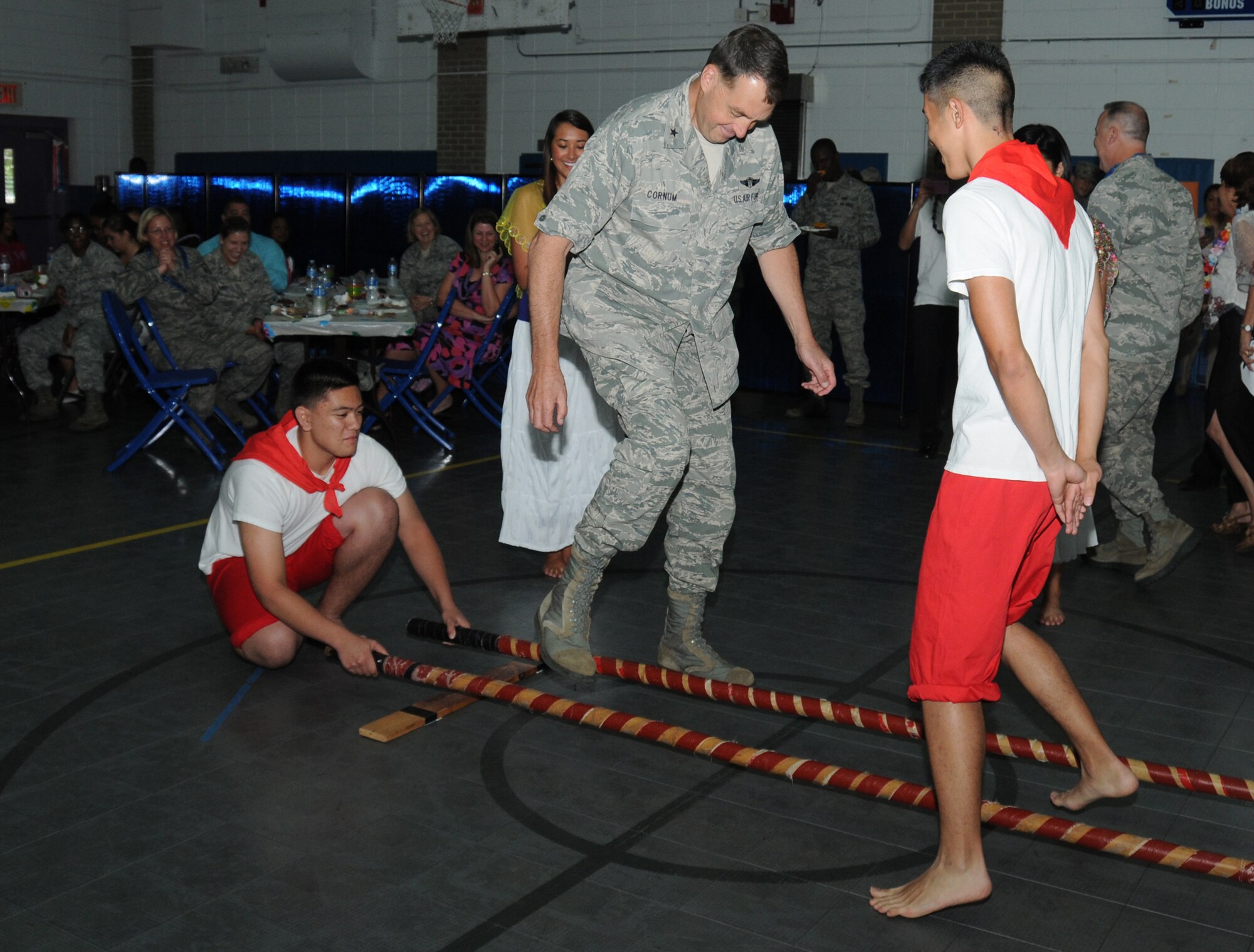 Brig. Gen. Kory Cornum, 81st Medical Group commander, attempts the Philippine dance, Tinikling, with the assistance of Joshua Roberts, 17, at the Asian-Pacific American Heritage cultural extravaganza at the Youth Center May 22, 2012, Keesler Air Force Base, Miss.  Joshua is the son of Lolita Roberts.  In addition to the variety of cultural dances performed there was also a food tasting and a fashion show.   (U.S. Air Force photo by Kemberly Groue)