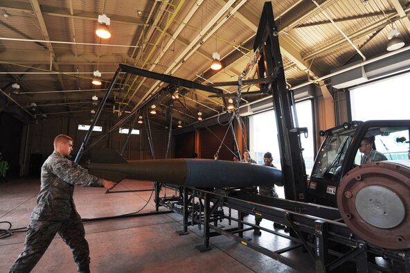 U.S. Air Force Airman 1st Class Dillon Barrett, left, 35th Maintenance Squadron conventional maintenance crew member, guides the BDU-50 training munition while it is being moved along the holding table at Misawa Air Base, Japan, May 31, 2012. When not in use, munitions go through a bomb teardown, or a disassembly. (U.S. Air Force photo by Airman Kenna Jackson/Released)