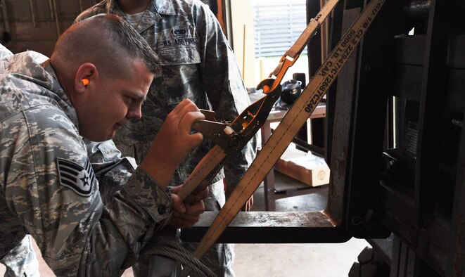 U.S. Air Force Staff Sgt. Craig Miezejeski, 35th Maintenance Squadron conventional maintenance crew chief, tightens the tie-down strap to the 6k lift truck prior to moving munitions at Misawa Air Base, Japan, May 31, 2012. The lift is used to relocate munitions too heavy for Airmen to move manually. (U.S. Air Force photo by Airman Kenna Jackson/Released)
