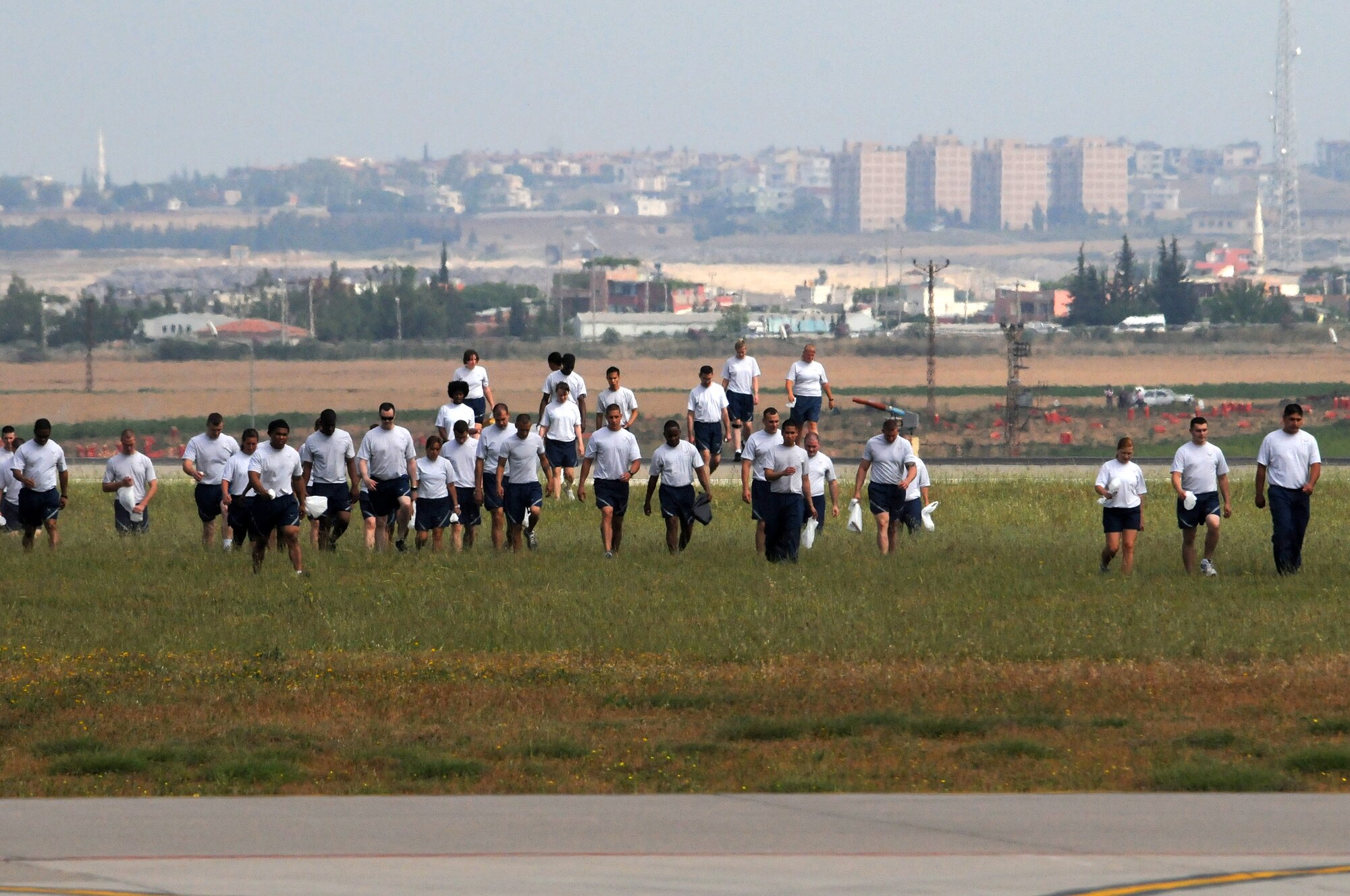 Airmen return from a field near the flightline during a foreign-object-debris walk May 29, 2012, at Incirlik Air Base, Turkey. The FOD walk was a combined effort between the 39th Air Base Wing and Turkish air force 10th Tanker Base Command to clear the area of  debris that could potentially damage aircraft engines. (U.S. Air Force photo by Senior Airman Marissa Tucker/Released)
