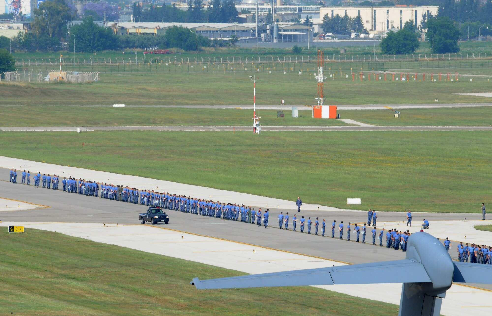 Turkish air force airmen from the 10th Tanker Base Command line up with 39th Air Base Wing Airmen in a foreign-object-debris walk on the flightline May 29, 2012, at Incirlik Air Base, Turkey. The FOD walk was held to clear the flightline area of trash and debris that could potentially damage aircraft engines. (U.S. Air Force photo by Senior Airman Marissa Tucker/Released)