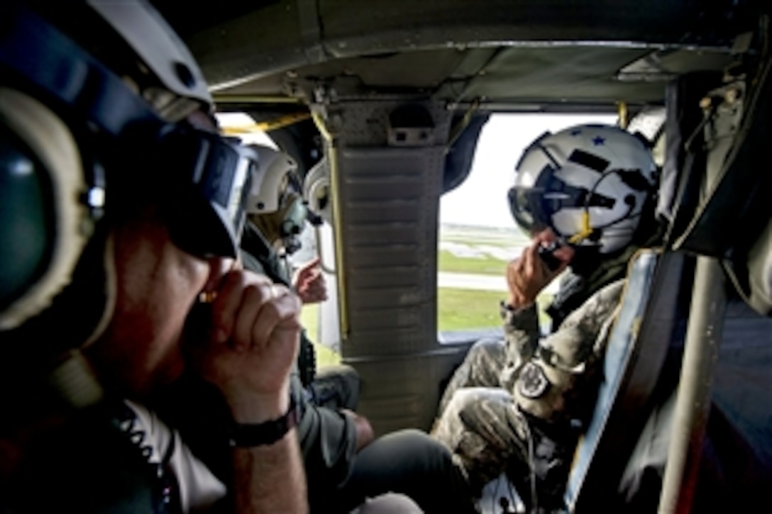 Navy Rear Adm. Paul J. Bushong, Joint Region Marianas commander, and Air Force Brig Gen. John W. Doucette, 36th Wing commander, brief Army Gen. Martin E. Dempsey, chairman of the Joint Chiefs of Staff, during a helicopter flight over Guam, May 30, 2012.