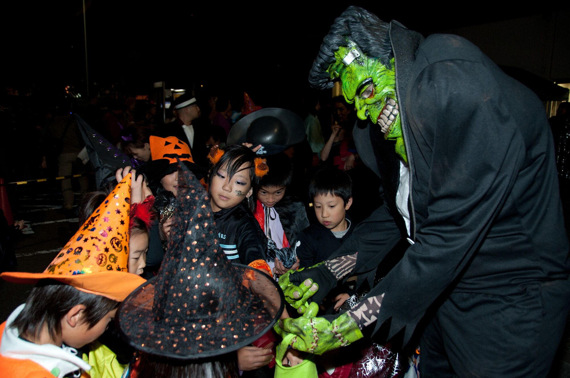 YOKOTA AIR BASE, Japan -- Children grab candy from a monster at the visitor's center Oct. 31, 2012, at Yokota Air Base, Japan. Yokota welcomed approximately 1,500 people for trick-or-treating festivities. (U.S. Air Force photo by Airman 1st Class Desiree Economides)
