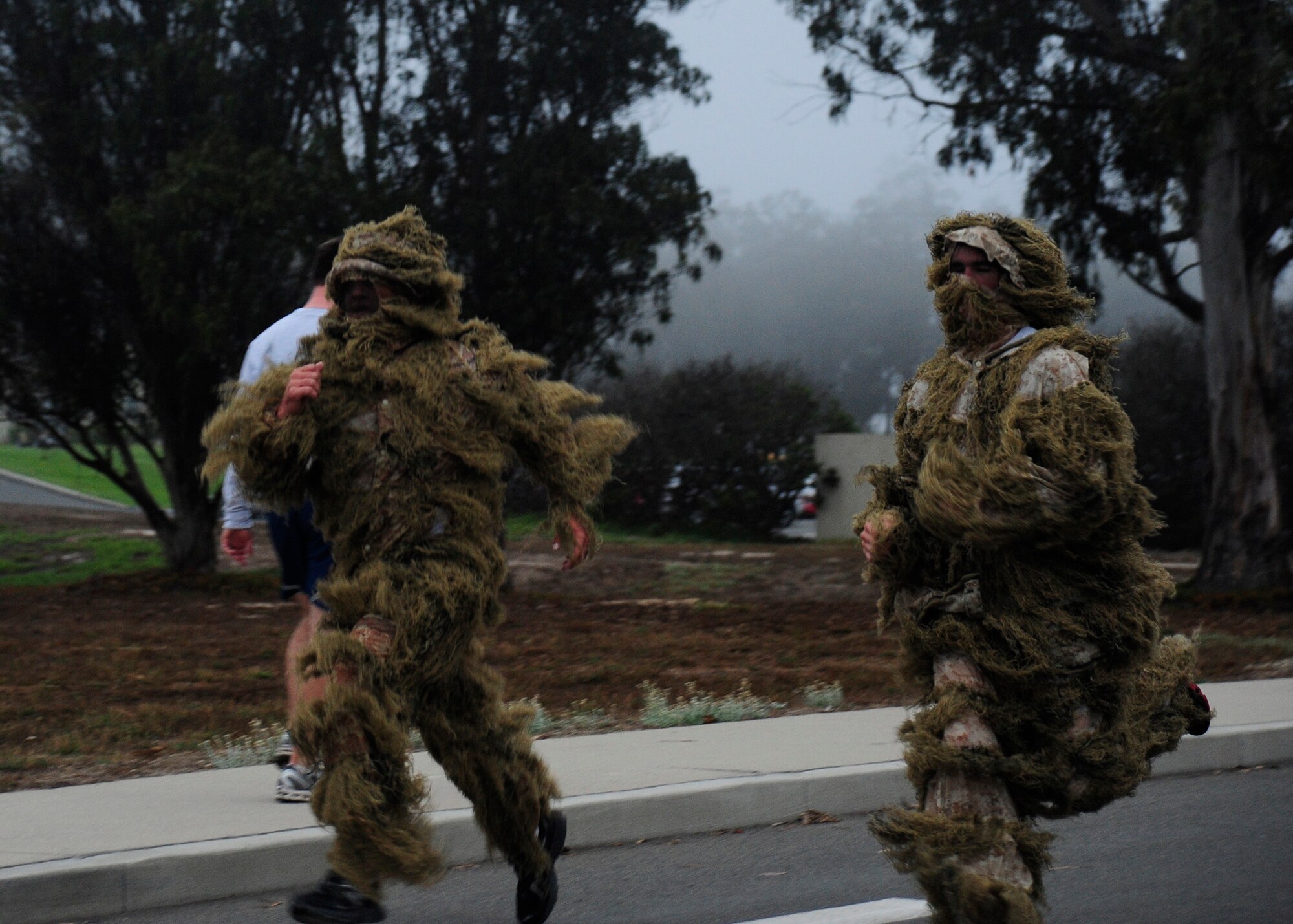 VANDENBERG AIR FORCE BASE, Calif. --Airman Kerry Line and Senior Airman Garrett Peltzer, 30th Civil Engineer Squadron members, sprint to the finish line during the monthly wing run here Wednesday, Oct. 31, 2012. Team V members were invited to participate in costume in celebration of Halloween. (U.S. Air Force photo/Michael Peterson)