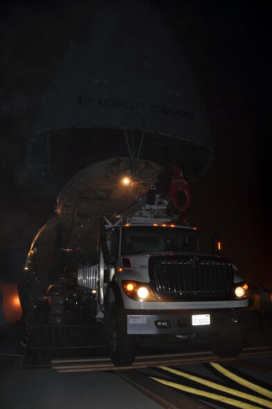 Reservists and technicians from March Air Reserve Base, Calif., answered the President's call to 'lean forward' with Hurricane Sandy relief efforts here Nov. 1, 2012, by loading Southern California Edison equipment onto a Travis Air Force Base C-5 Galaxy and a Joint Base Lewis-McChord C-17 Globemaster III. Here an Edison truck is loaded into the cargo bay of a C-5. (U.S. Air Force photo/Linda Welz) 