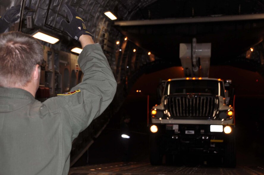 Reservists and technicians from March Air Reserve Base, Calif., answered the President's call to 'lean forward' with Hurricane Sandy relief efforts here Nov. 1, 2012, by loading Southern California Edison equipment onto a Travis Air Force Base C-5 Galaxy and a Joint Base Lewis-McChord C-17 Globemaster III. Here an Edison truck is loaded into the cargo bay of a C-17. (U.S. Air Force photo/Linda Welz) 