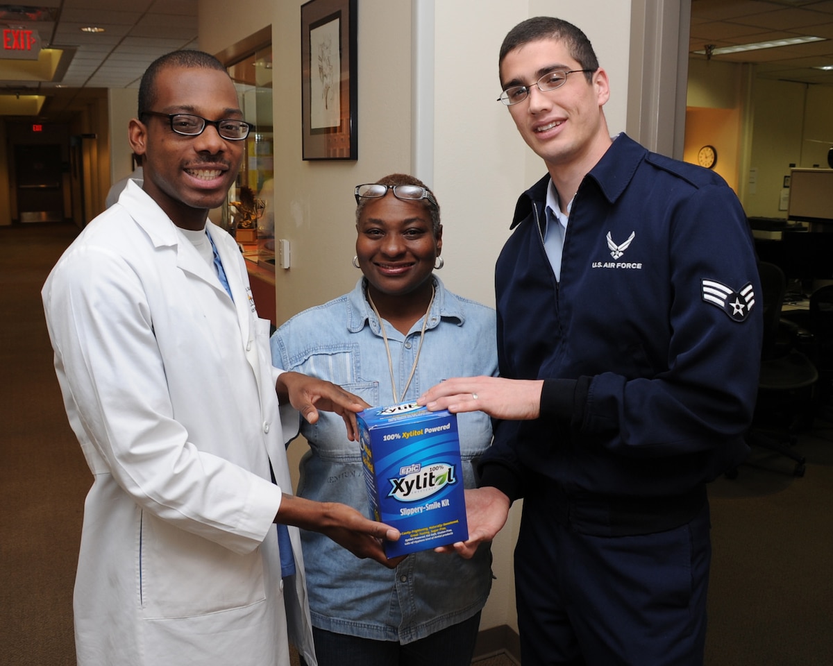 KIRTLAND AFB, N.M. -- From left, Airman 1st Class Raewyn Reyes, Austra Judice and Senior Airman Kyle Folterman display a “Cavity-Free Kit.” (Photo by Todd Berenger)