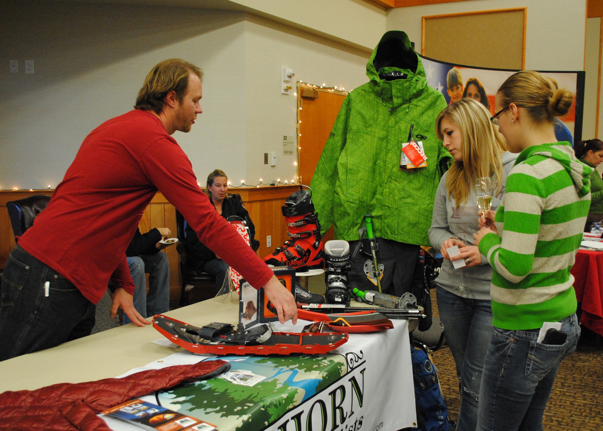 Chris Leatham, a Bighorn Outdoor specialist, explains how snowshoes work to Staff Sgt. Cassandra Hout, right, 341st Force Support Squadron command support staff member, and her friend Kori Baie.  More than 130 members of Team Malmstrom attended the event and had a chance to win dozens of prizes, including goggles, ski tune-ups, season passes and a three-day/three-night ski and stay package for two adults at Whitefish Mountain Resort. (U.S. Air Force photo/Airman 1st Class Katrina Heikkinen)