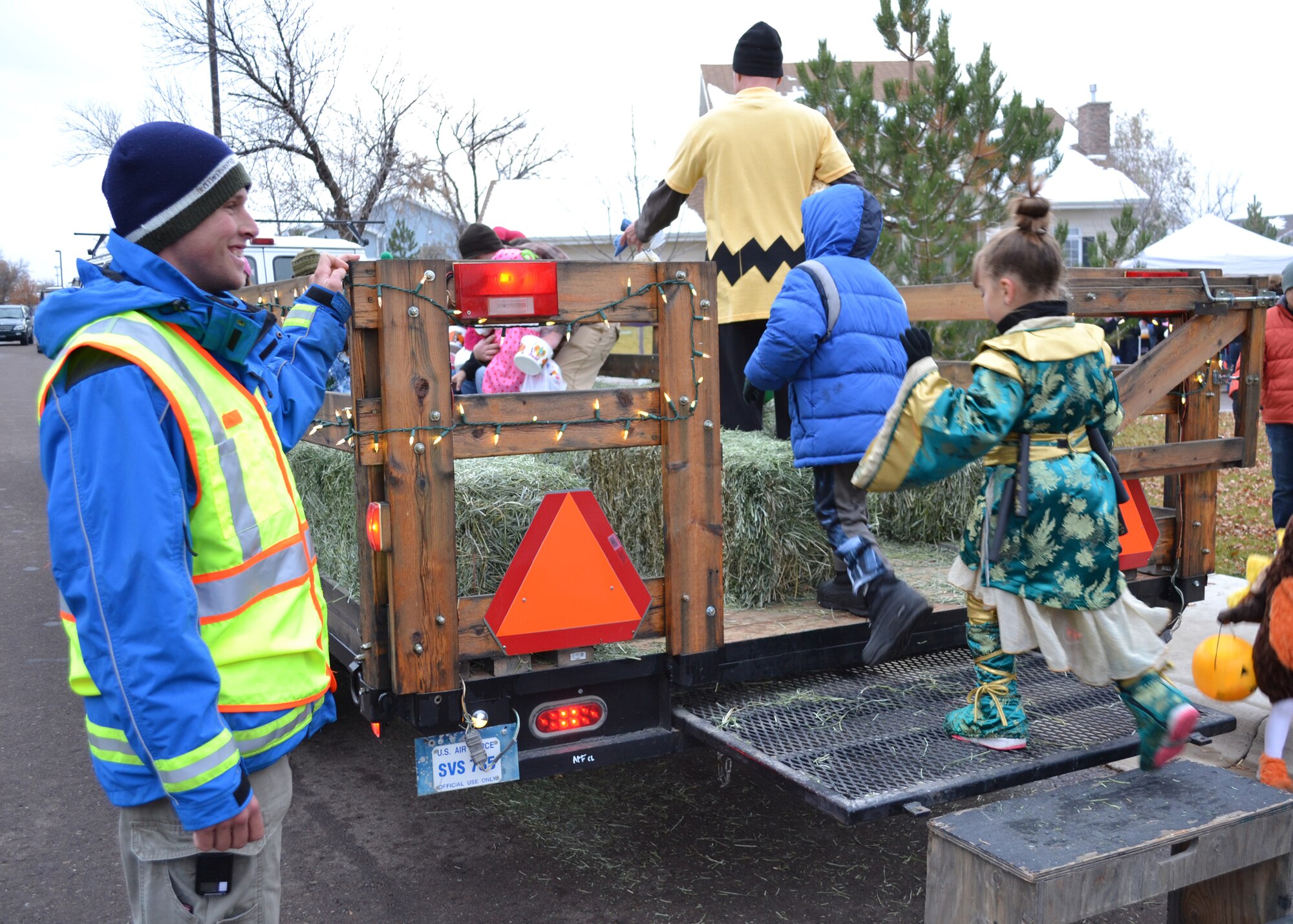 Senior Airman Tracy Wetzel, 819th RED HORSE Squadron pavement and equipment operator, watches as children and their parents board the hayrack ride to leave the commander’s Halloween party on Oct. 26.  The hayrack ride was provided by Outdoor Recreation as a means for families to go to and from the party safely.  (U.S. Air Force photo/Airman 1st Class Cortney Paxton)