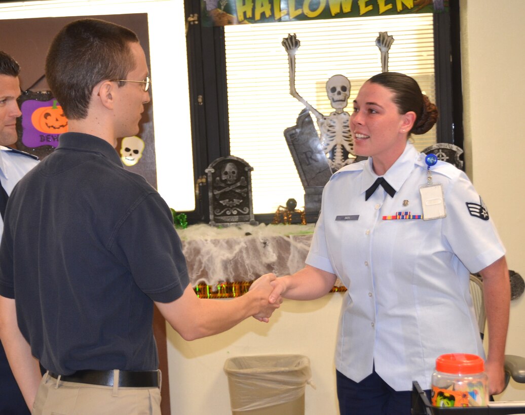 Adam Bond, center,  thanks Senior Airman Ciara Bien at Keesler Air Force Base, Miss., Oct. 22, 2012, for her actions following an  Oct. 20 accident that involved his brother, as Lt. Col. Tommy Franklin, acting 81st MDSS commander, looks on. Bien is with the 81st Medical Support Squadron and Bond is a photographer with KMAR Industries at Keesler Air Force Base. (U.S. Air Force photo/Stephen Pivnick)