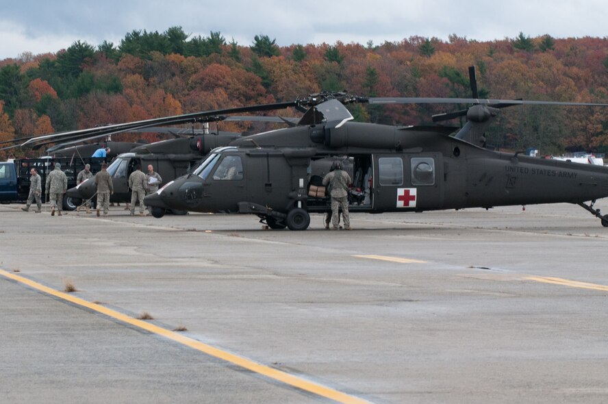 HANSCOM AIR FORCE BASE, Mass. – Members aboard three UH-60 Blackhawk helicopters offload equipment on the flightline here Oct. 31. The brigade is at Hanscom as part of the USNORTHCOM Defense Support of Civil Authorities mission that directs the command to plan and anticipate action that it may need to take to support civil authorities. USNORTHCOM plays an important role in disaster response; however, all efforts for Hurricane Sandy are in support of FEMA, working closely with state and local officials. (U.S. Air Force photo by Rick Berry)