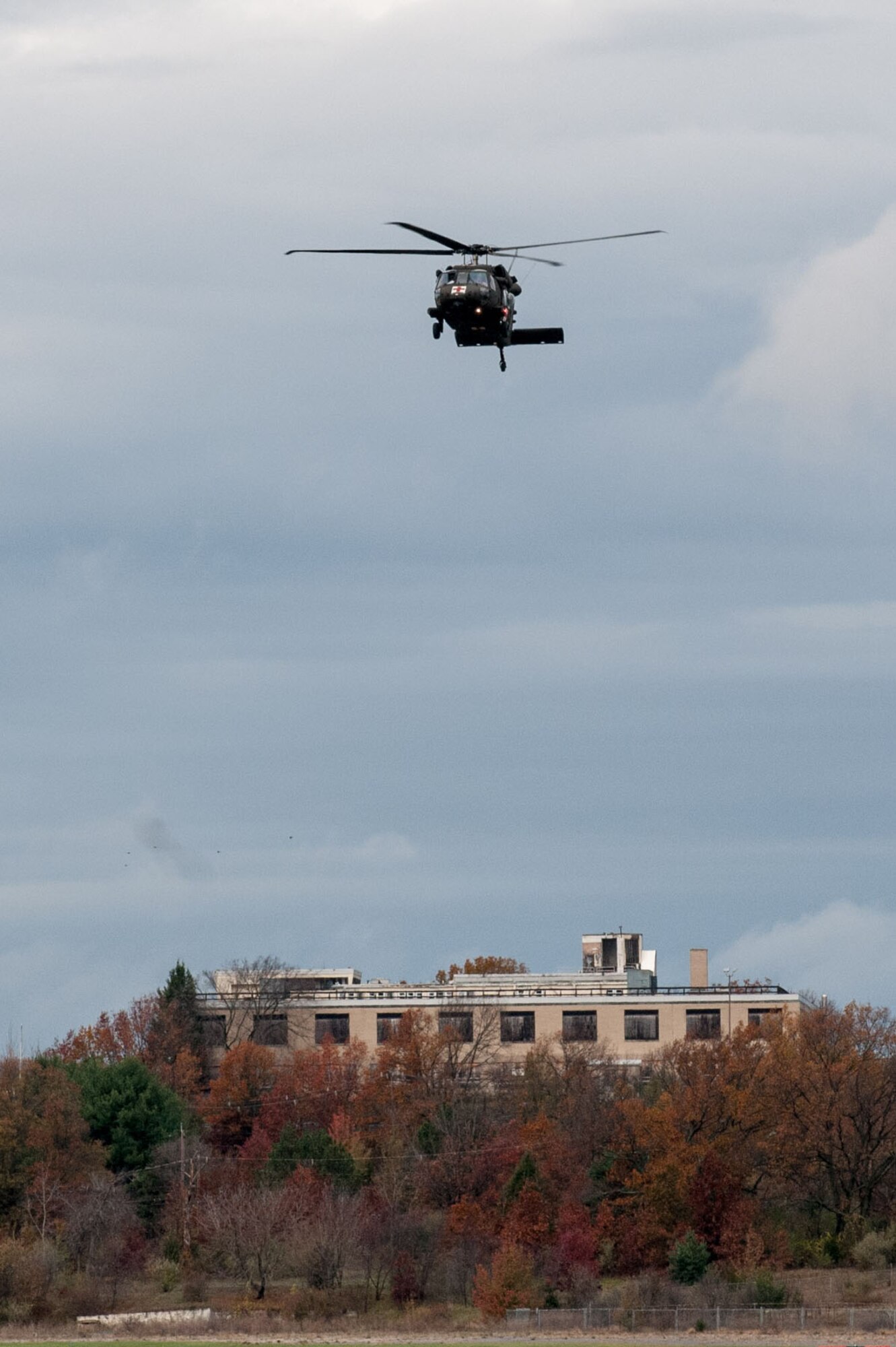 HANSCOM AIR FORCE BASE, Mass. -- A UH-60 Blackhawk helicopter ferrying members of the 10th Mountain Division Combat Aviation Brigade flies over a building near the Hanscom flightline Oct. 31. The brigade is at Hanscom as part of the USNORTHCOM Defense Support of Civil Authorities mission that directs the command to plan and anticipate action that it may need to take to support civil authorities. USNORTHCOM plays an important role in disaster response; however, all efforts for Hurricane Sandy are in support of FEMA, working closely with state and local officials. (U.S. Air Force photo by Rick Berry)