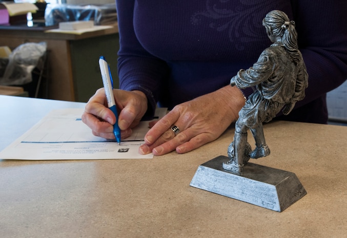 Judi Horry, 628th Force Support Squadron Arts and Crafts director, takes an engraving order from a customer Oct. 29, 2012 at Joint Base Charleston - Air Base, S.C. The laser engraver is used to personalize metal plates, glass, acrylic and wood with names and sentiments. (U.S. Air Force photo/Airman 1st Class Ashlee Galloway)