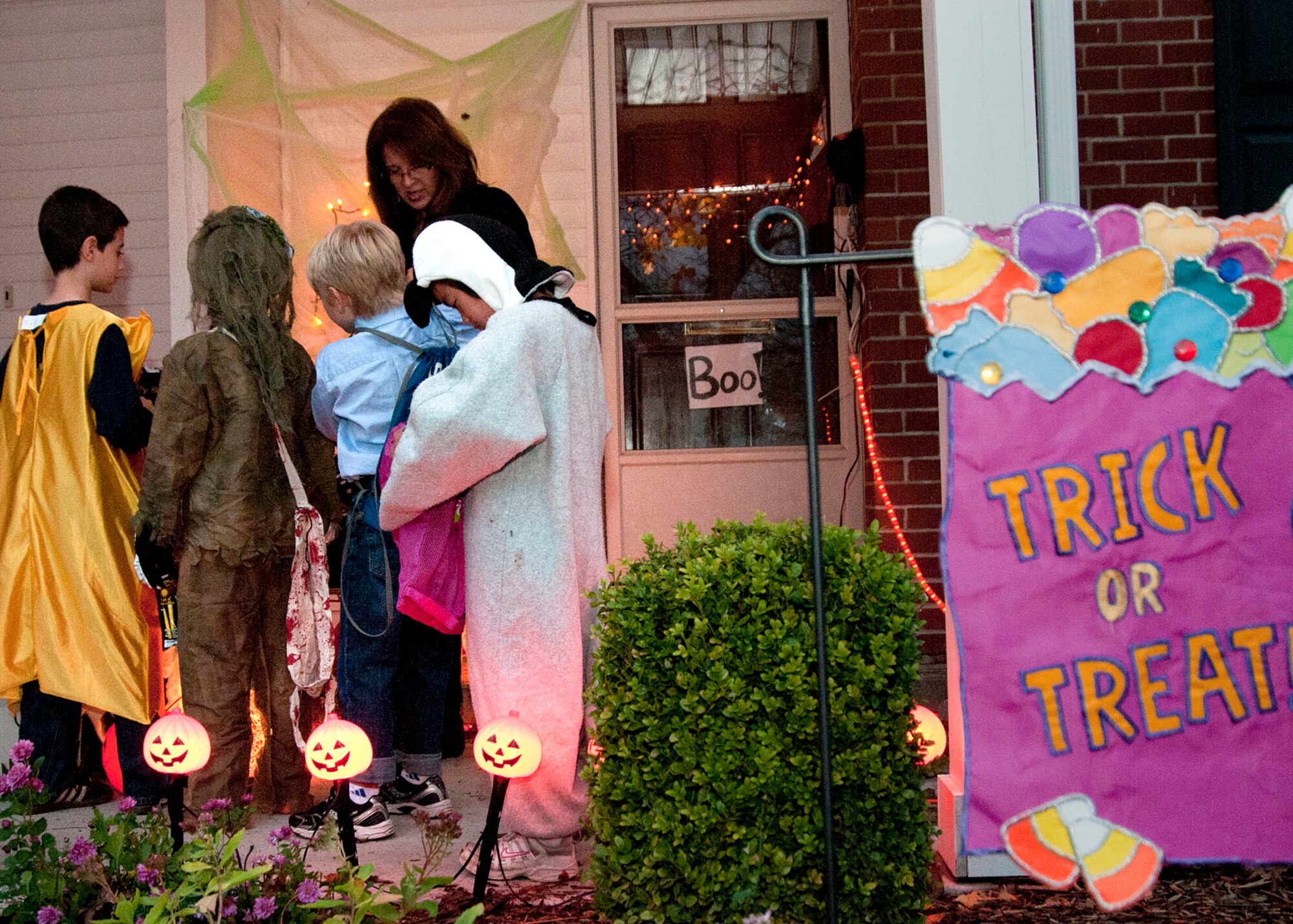 HANSCOM AIR FORCE BASE, Mass. -- Cheryl Carty passes out candy to children at her house Oct. 31 during Halloween's trick-or-treating. Children dressed as goblins, ghosts, witches or their favorite characters and ran from house to house looking for their favorite treats. (U.S. Air Force Base photo by Mark Wyatt)