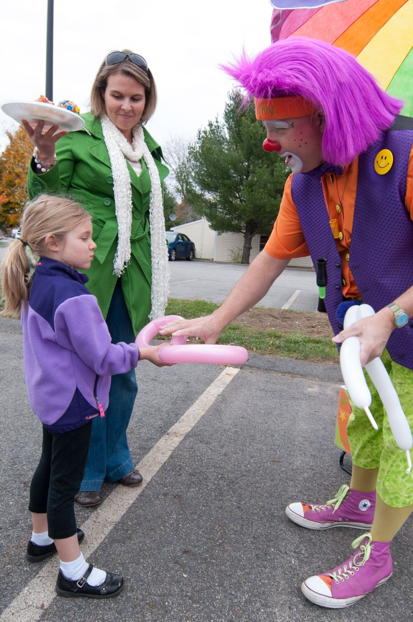 HANSCOM AIR FORCE BASE, Mass. -- Silly Willy the Clown makes a balloon sculpture for McKenna Sollee, age 5, at the Fall Festival held in base housing Oct. 24. Activities also included face painting, a coloring contest, a bouncy house and more. (U.S. Air Force Photo by Rick Berry)