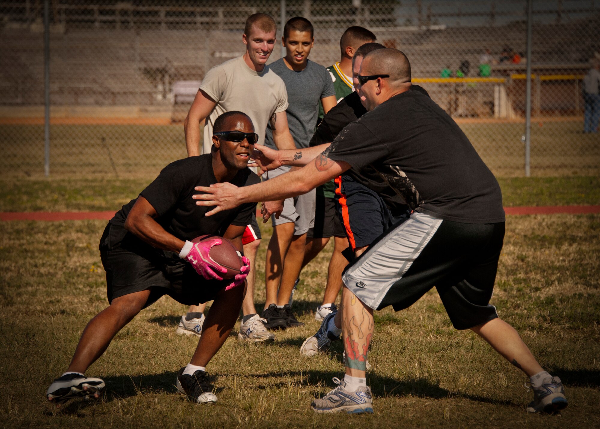 Senior Airman Christopher Simmons, of the 96th Logistics Readiness Squadron, tries dodging his opponent in the 96th LRS non-commissioned officers versus Airmen two-hand-touch football game at the 96th Test Wing’s Wingman Day event Oct. 31 at Eglin Air Force Base, Fla.  Hundreds of Airmen and civilians participated in physical and non-physical challenges highlighting teamwork and resiliency.  (U.S. Air Force photo/Randy Gon)