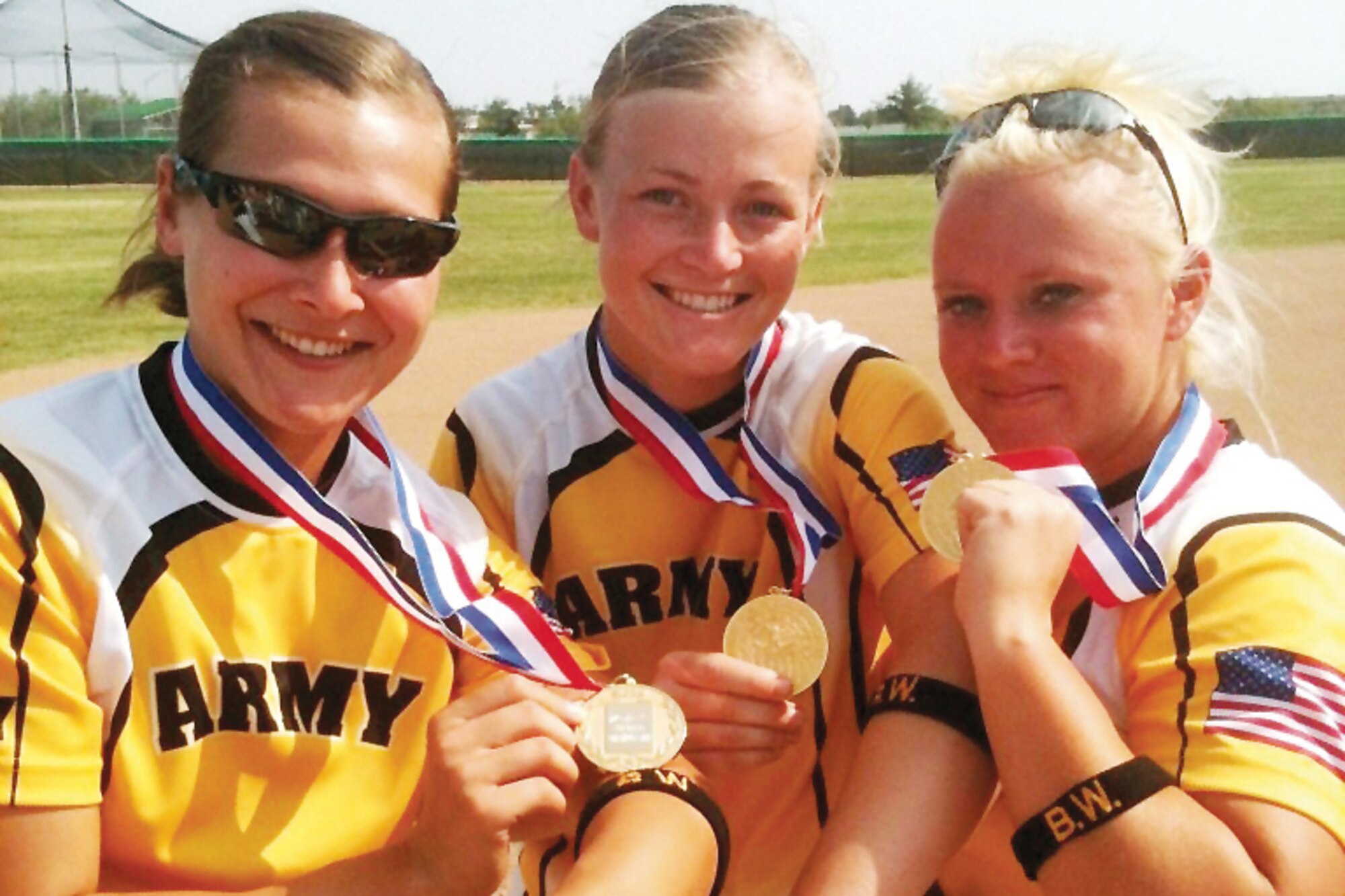 2012 All-Army Women’s Softball teammates, 1st Lt. Alyson McWherter, Sgt. Ashley Walker, and Staff Sgt. Nicole Dunn, gather together just after securing the tournament championship to display their gold medals and arm bands with Sgt. Brian Walker’s
initials embroidered on them Sept. 20. The team wore the arm bands during all of their games this year as a way to remember and honor Brian who was killed during combat operations in Afghanistan May 13. (Courtesy photo)
