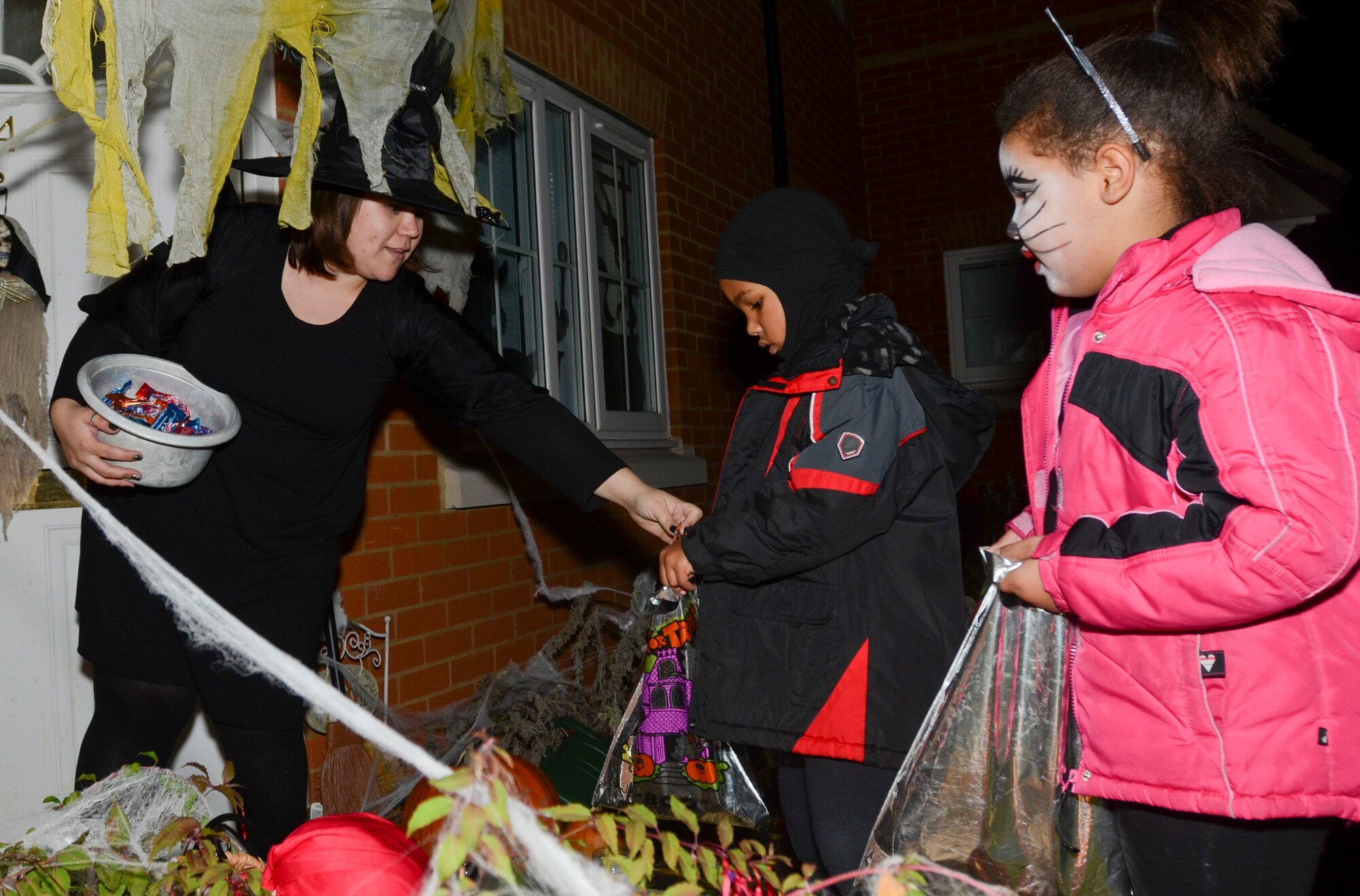 ROYAL AIR FORCE LAKENHEATH, England - Brooke Standage, wife of Staff Sgt. Christopher Standage, 48th Medical Support Squadron, passes out candy to trick-or-treaters Oct. 31, 2012. Trick-or-treaters made their rounds at RAFs Lakenheath and Feltwell from 6 - 8 p.m., gathering lots of Halloween treats. (U.S. Air Force photo by Staff Sgt. Stephen Linch)