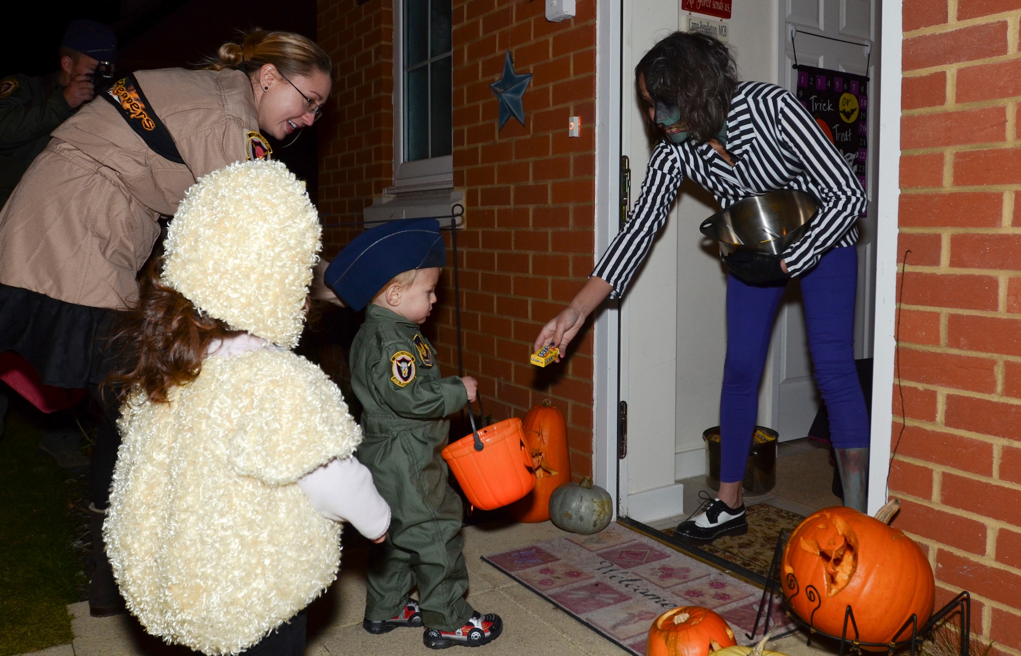 ROYAL AIR FORCE LAKENHEATH, England - Carmen Aragon, daughter of Tech. Sgt. Gabriel Aragon, RAF Mildenhall, passes out candy to trick-or-treaters Oct. 31, 2012. Trick-or-treaters made their rounds at RAFs Lakenheath and Feltwell from 6 - 8 p.m., gathering lots of Halloween treats. (U.S. Air Force photo by Staff Sgt. Stephen Linch)