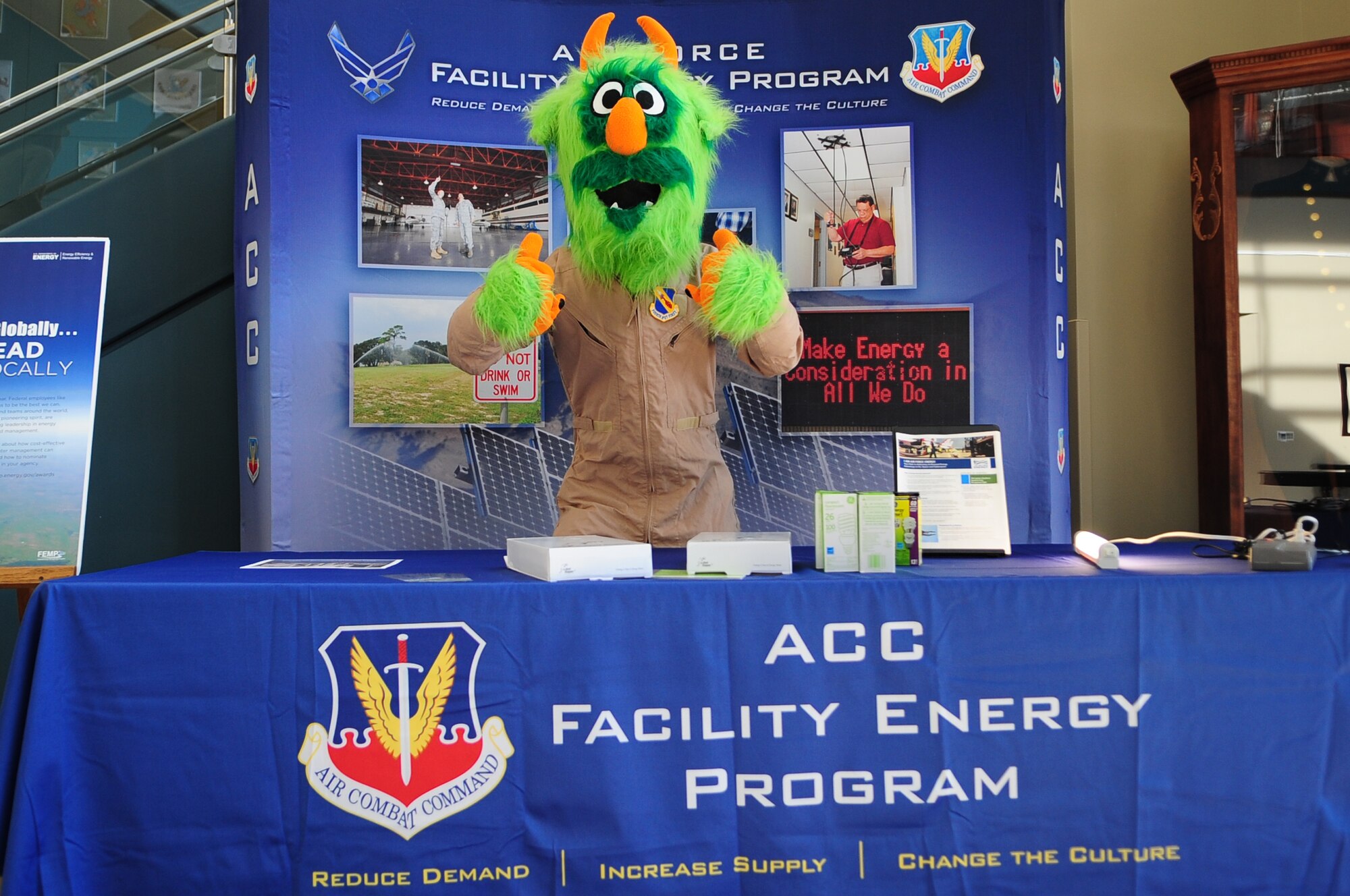 “Airman e-BEAST,” 4th Civil Engineer Squadron energy awareness mascot, gives a thumbs up as he stands by a display at the Consolidated Support Center on Seymour Johnson Air Force Base, N.C., Oct. 17, 2012. According to the base energy manager, since the center opened it has saved more than $32,000 in energy-related costs. (U.S. Air Force photo/Airman 1st Class Aubrey White/Released)