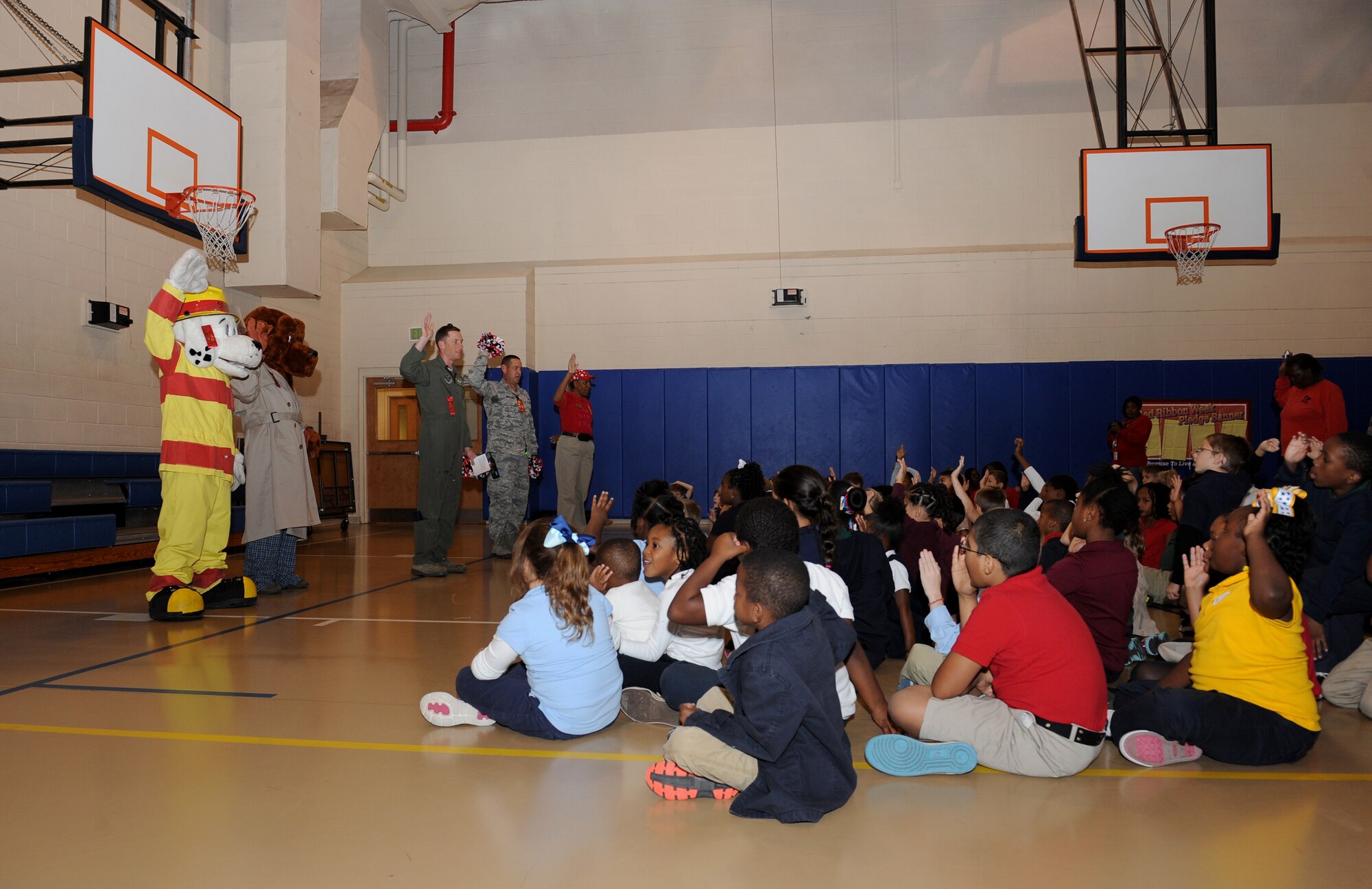 Children from the youth center raise their hand to pledge to be drug-free as part of Red Ribbon Week on Barksdale Air Force Base, La., Oct. 30. Col. Alexis Mezynski, 2nd Bomb Wing vice commander, Chief Master Sgt. Larry Malcom, 2 BW command chief, Sparky the Fire Dog and McGruff the Crime Dog visited the youth center to inform more than 80 children about the negative effects of substance-abuse. (U.S. Air Force photo/Airman 1st Class Benjamin Gonsier)(RELEASED)
