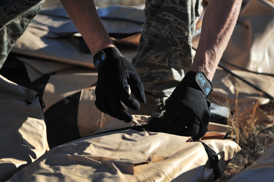 An Airman with the 27th Special Operations Wing at Cannon Air Force Base, N.M., unstraps secured supplies during an exercise at Melrose Air Force Range, N.M., Oct. 29, 2012. Aircraft maneuvered troops and cargo from agencies across Cannon to better prepare personnel for potential real-world events. (U.S. Air Force photo/Airman 1st Class Alexxis Pons Abascal)  