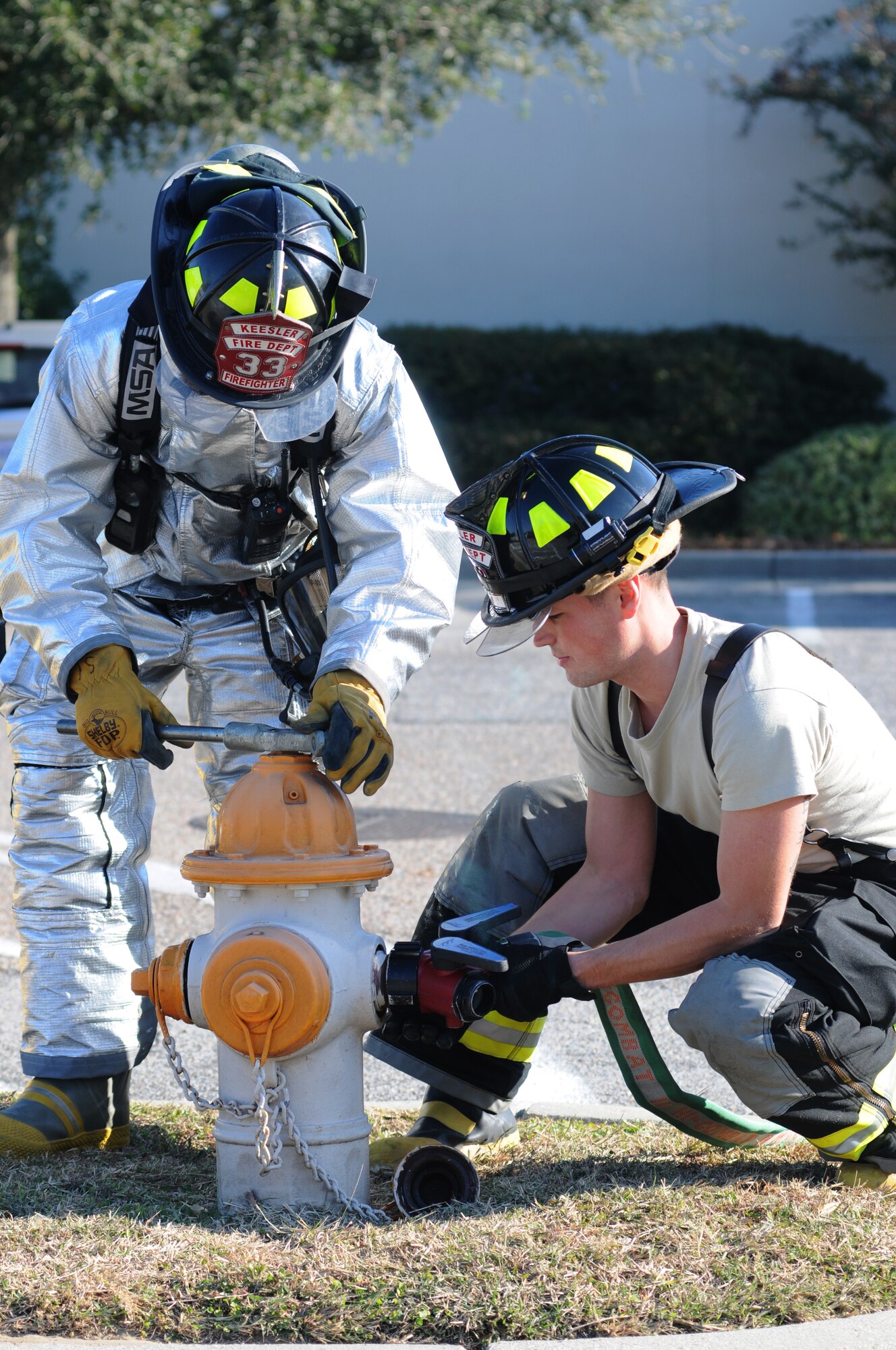 Airman 1st Class Seth Corn and Senior Airman Christopher Lecomte, Keesler firefighters, attach water hoses to a fire hydrant for water access to be used in the hazardous material decontamination pool for “victims” during a hazardous material and major accident response exercise Oct. 31, 2012, at Hangar 4, Keesler Air Force Base, Miss.  The exercise scenario consisted of a group of Airmen cleaning inside the hangar in preparation for demolition when a shelf holding old munitions fell to the ground causing one to break open, explode and splash an “oily substance” on several of the “victims.”  The exercise helped prepare first responders in the event of a real-world incident.  (U.S. Air Force photo by Kemberly Groue)