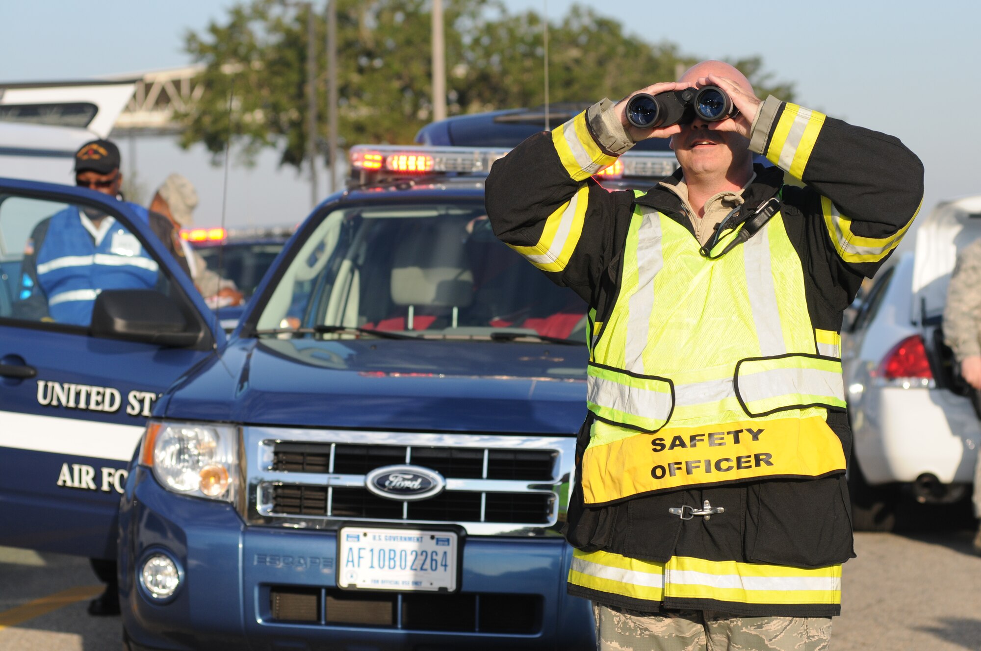 Master Sgt. Jerame Bullard, Keesler firefighter, uses binoculars to view the site of contamination during a hazardous material and major accident response exercise Oct. 31, 2012, at Hangar 4, Keesler Air Force Base, Miss.  The exercise scenario consisted of a group of Airmen cleaning inside the hangar in preparation for demolition when a shelf holding old munitions fell to the ground causing one to break open, explode and splash an “oily substance” on several of the “victims.”  The exercise helped prepare first responders in the event of a real-world incident.  (U.S. Air Force photo by Kemberly Groue)