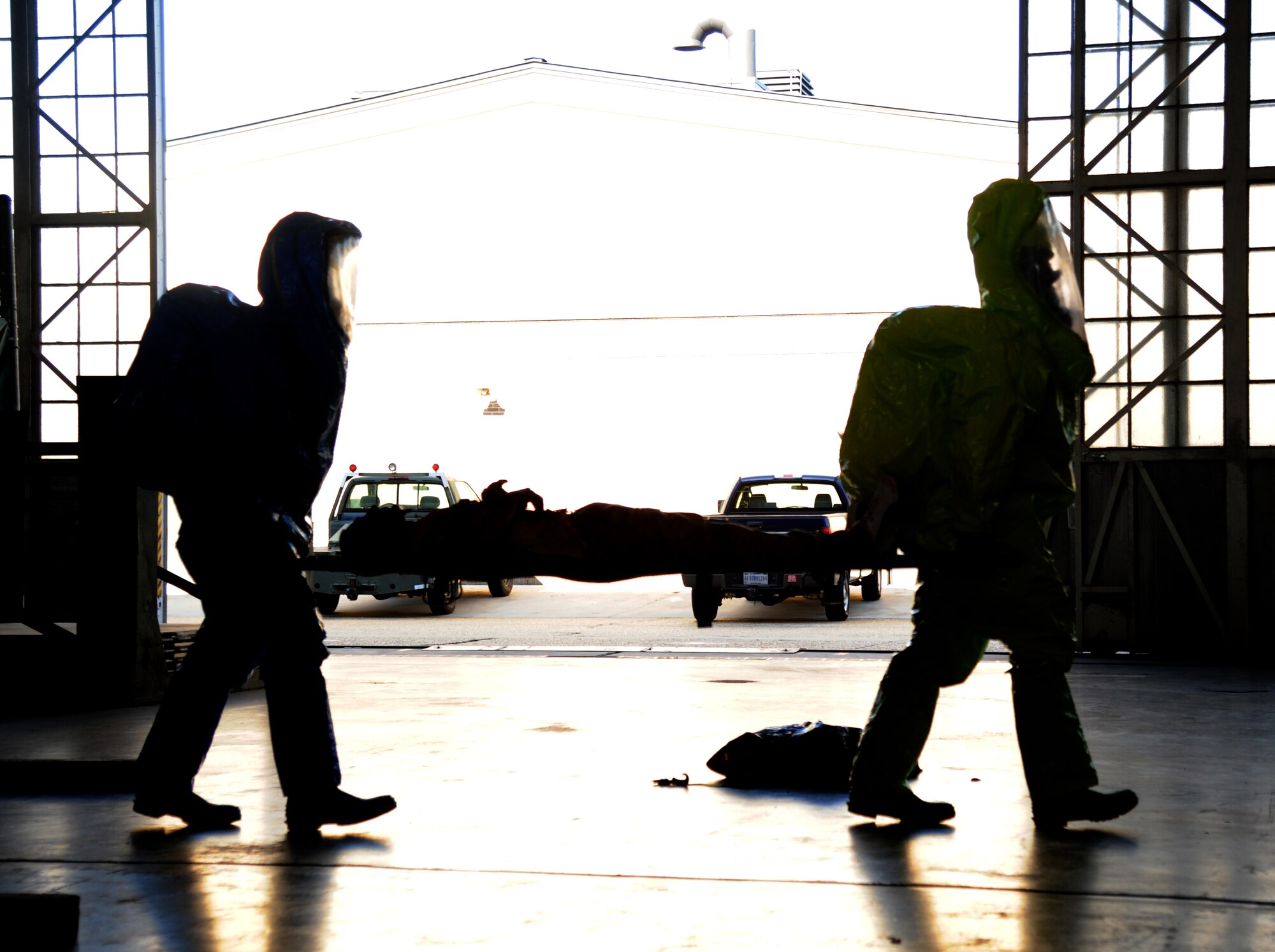 Keesler fire HAZMAT rescue entry team carry an injured “victim” out of the contaminated area to receive medical treatment during a hazardous material and major accident response exercise Oct. 31, 2012, at Hangar 4, Keesler Air Force Base, Miss.  The exercise scenario consisted of a group of Airmen cleaning inside the hangar in preparation for demolition when a shelf holding old munitions fell to the ground causing one to break open, explode and splash an “oily substance” on several of the “victims.”  The exercise helped prepare first responders in the event of a real-world incident.  (U.S. Air Force photo by Kemberly Groue)