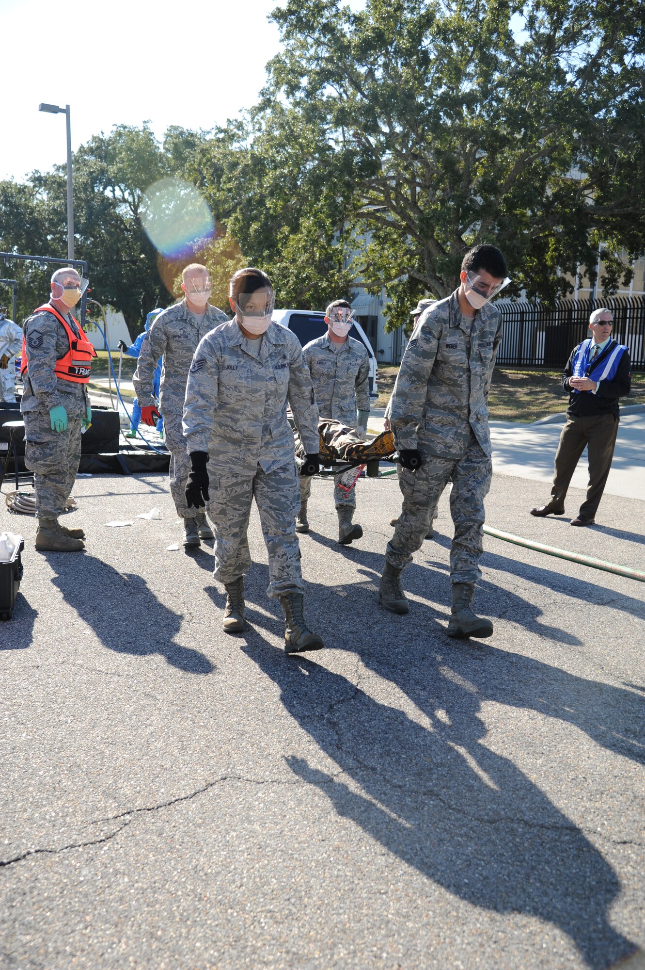 Members of the 81st Medical Group carry an injured “victim” to the triage area to receive medical treatment during a hazardous material and major accident response exercise Oct. 31, 2012, at Hangar 4, Keesler Air Force Base, Miss.  The exercise scenario consisted of a group of Airmen cleaning inside the hangar in preparation for demolition when a shelf holding old munitions fell to the ground causing one to break open, explode and splash an “oily substance” on several of the “victims.”  The exercise helped prepare first responders in the event of a real-world incident.  (U.S. Air Force photo by Kemberly Groue)